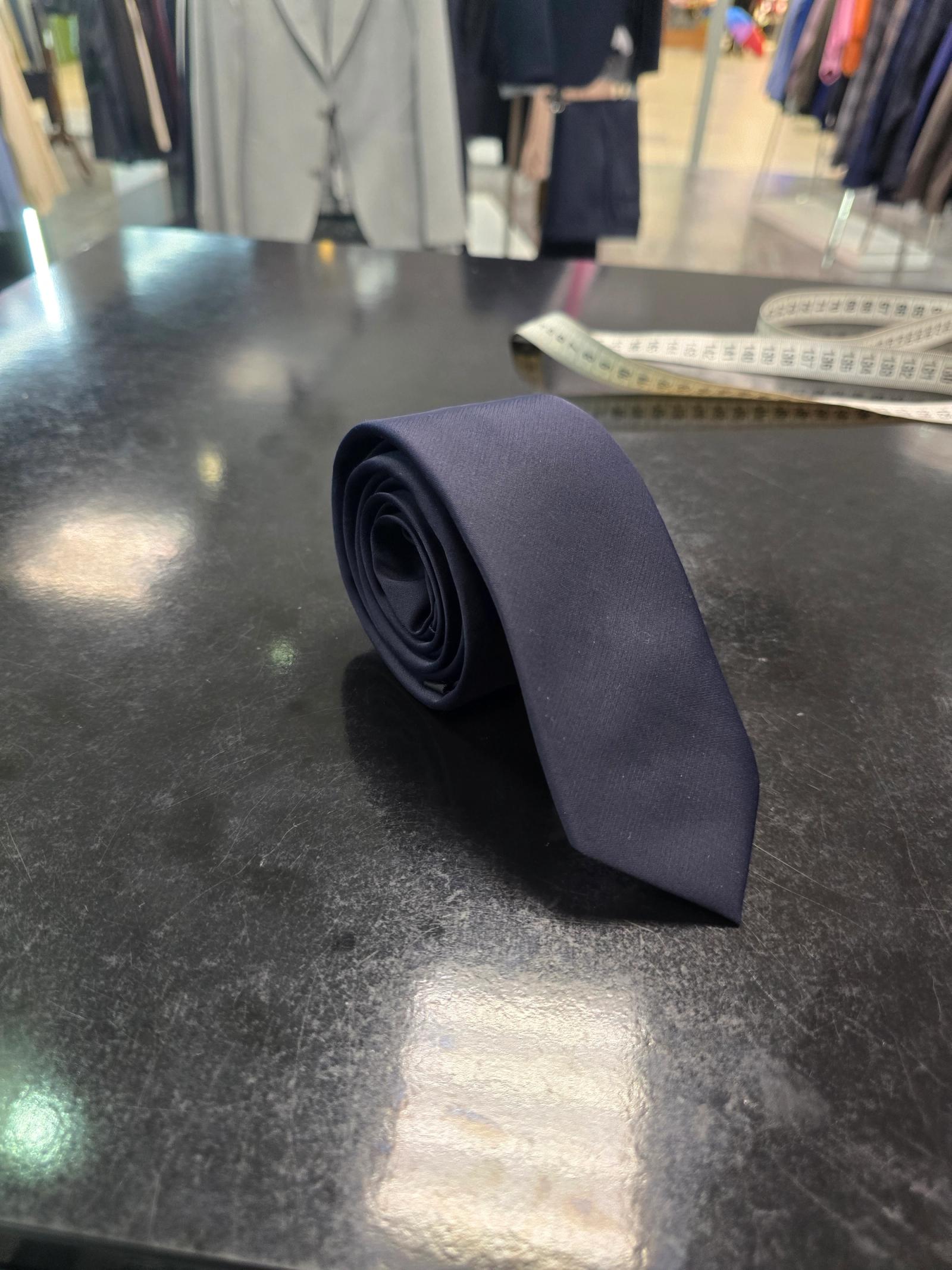 Viento slim navy tie, rolled view on dark counter