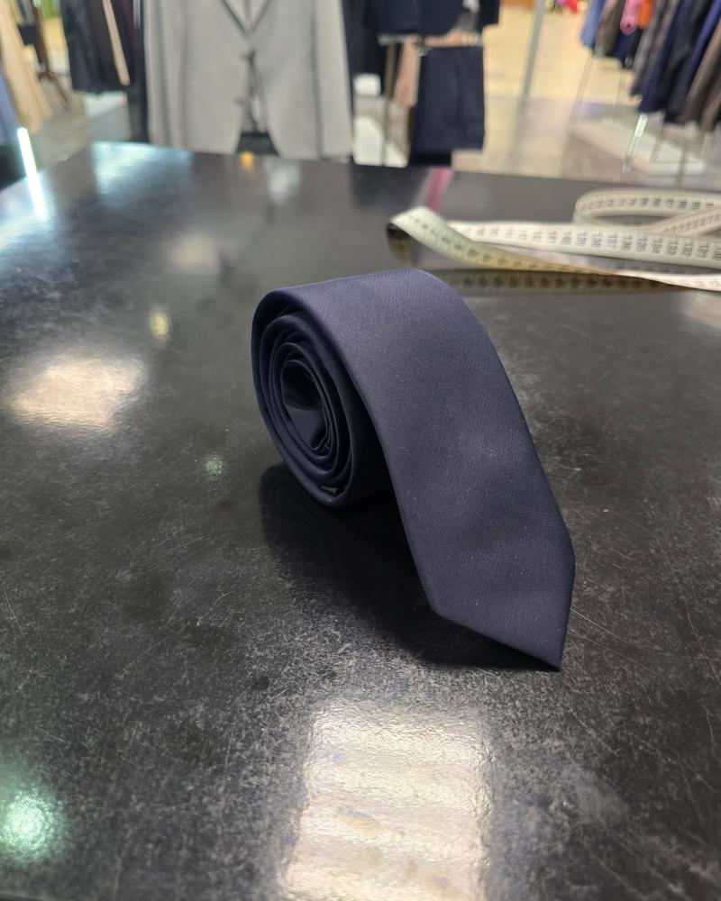Viento slim navy tie, rolled view on dark counter