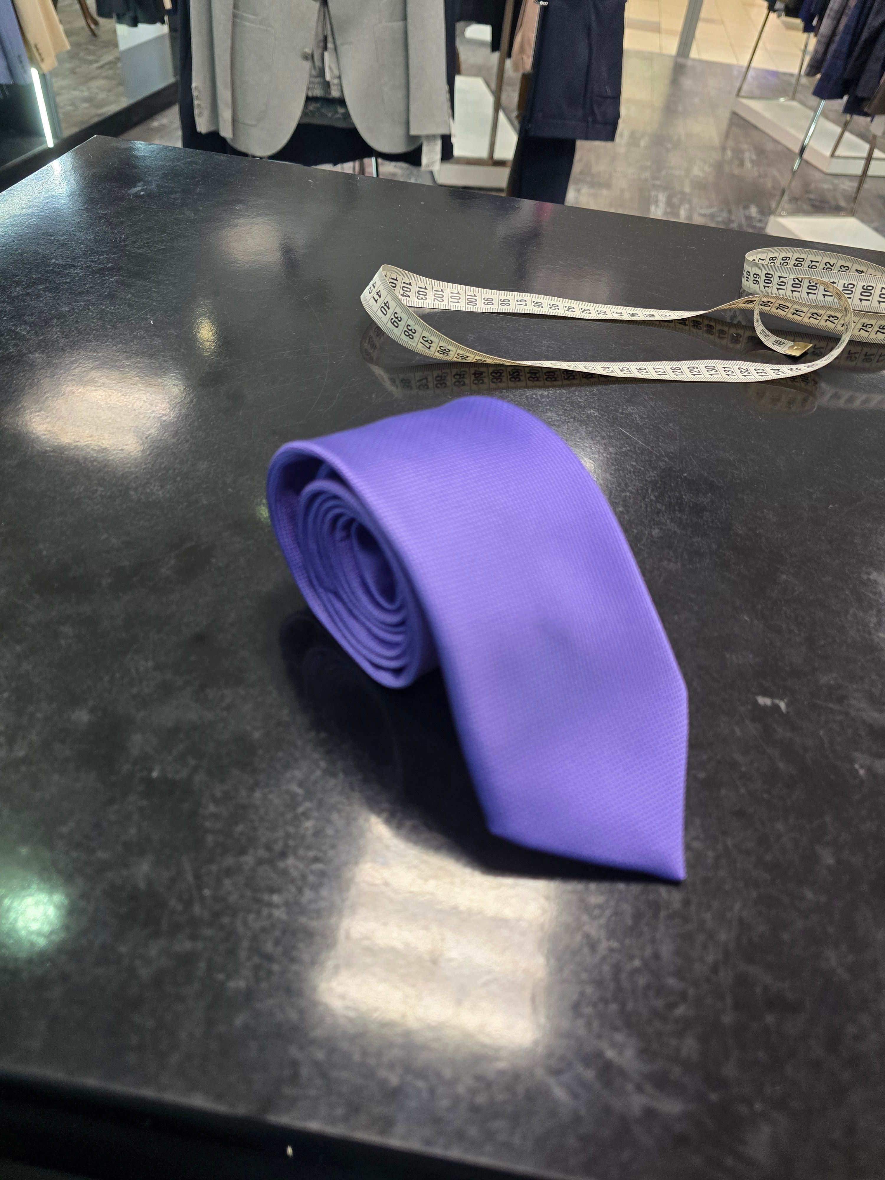 Viento purple tie, rolled view on dark counter