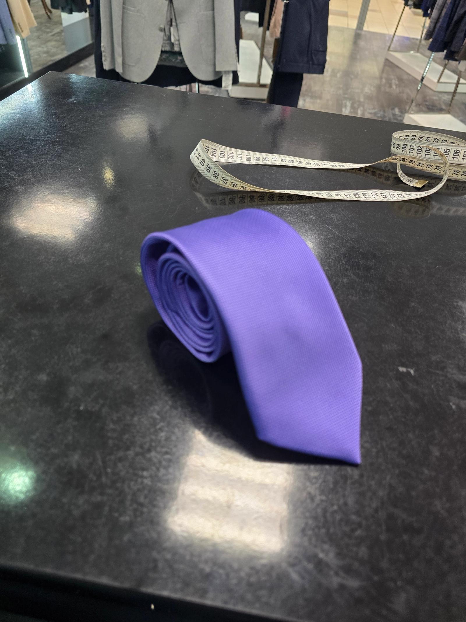 Viento purple tie, rolled view on dark counter