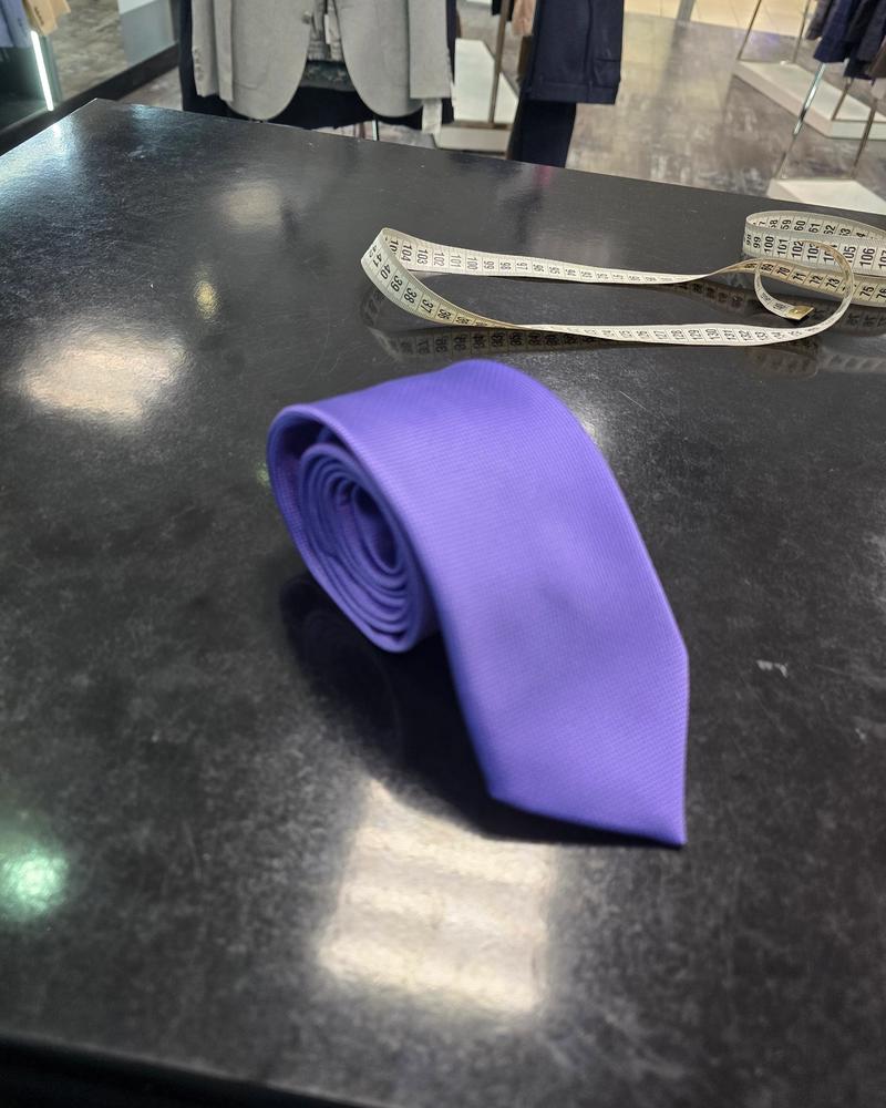 Viento purple tie, rolled view on dark counter