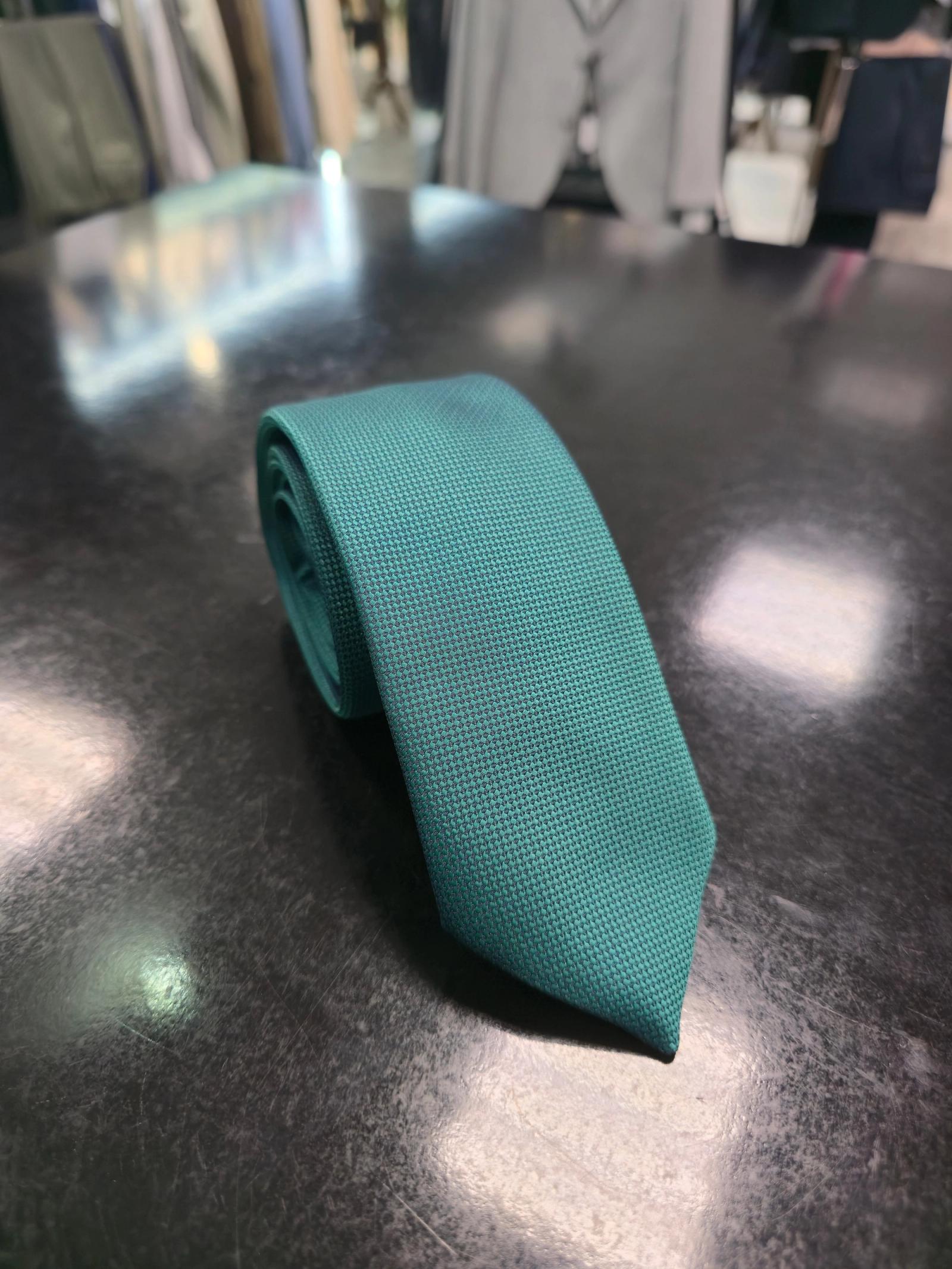 Viento textured teal green tie, full length on dark counter