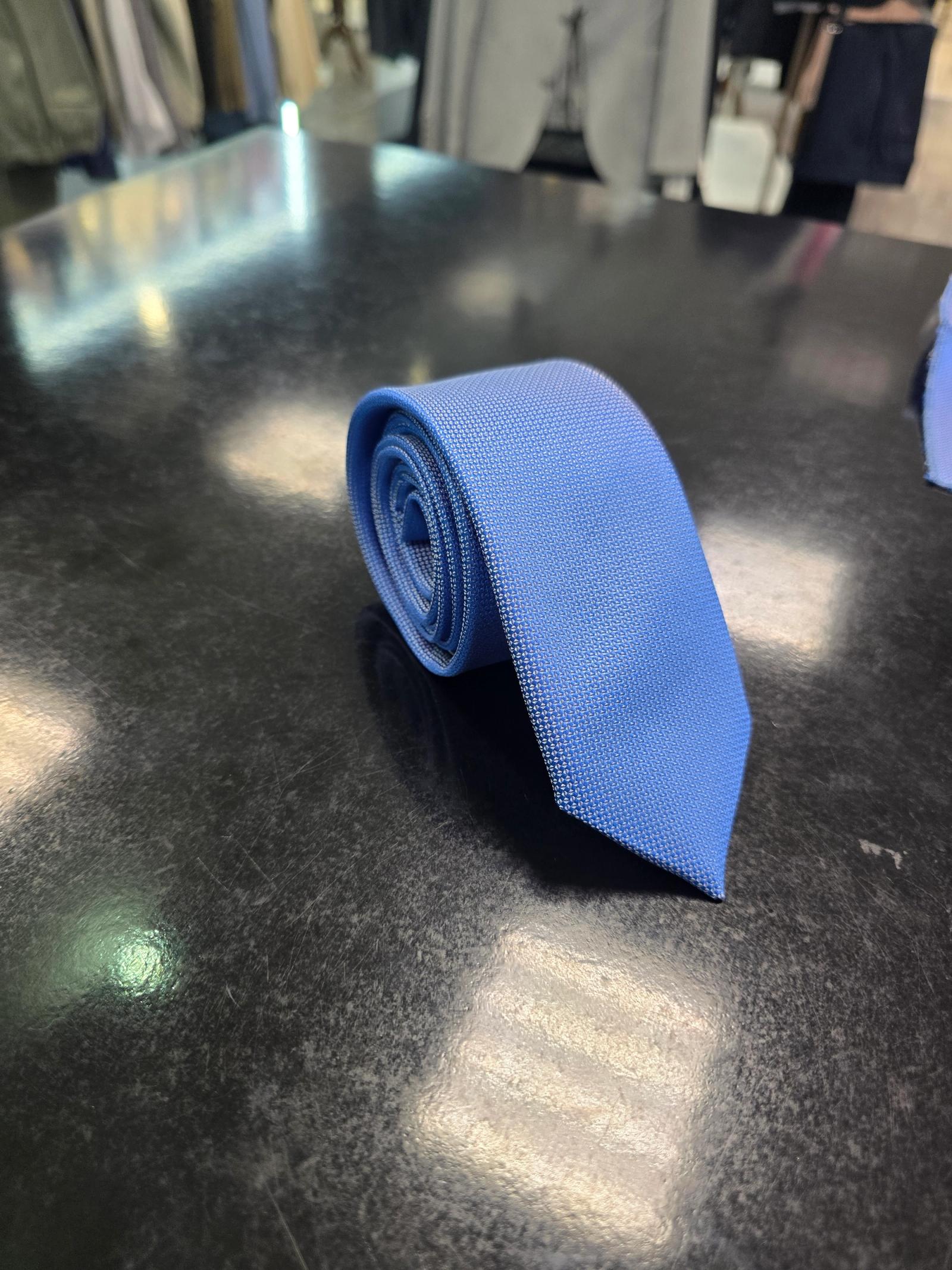 Viento textured cornflower blue tie, vertical full-length view on dark counter