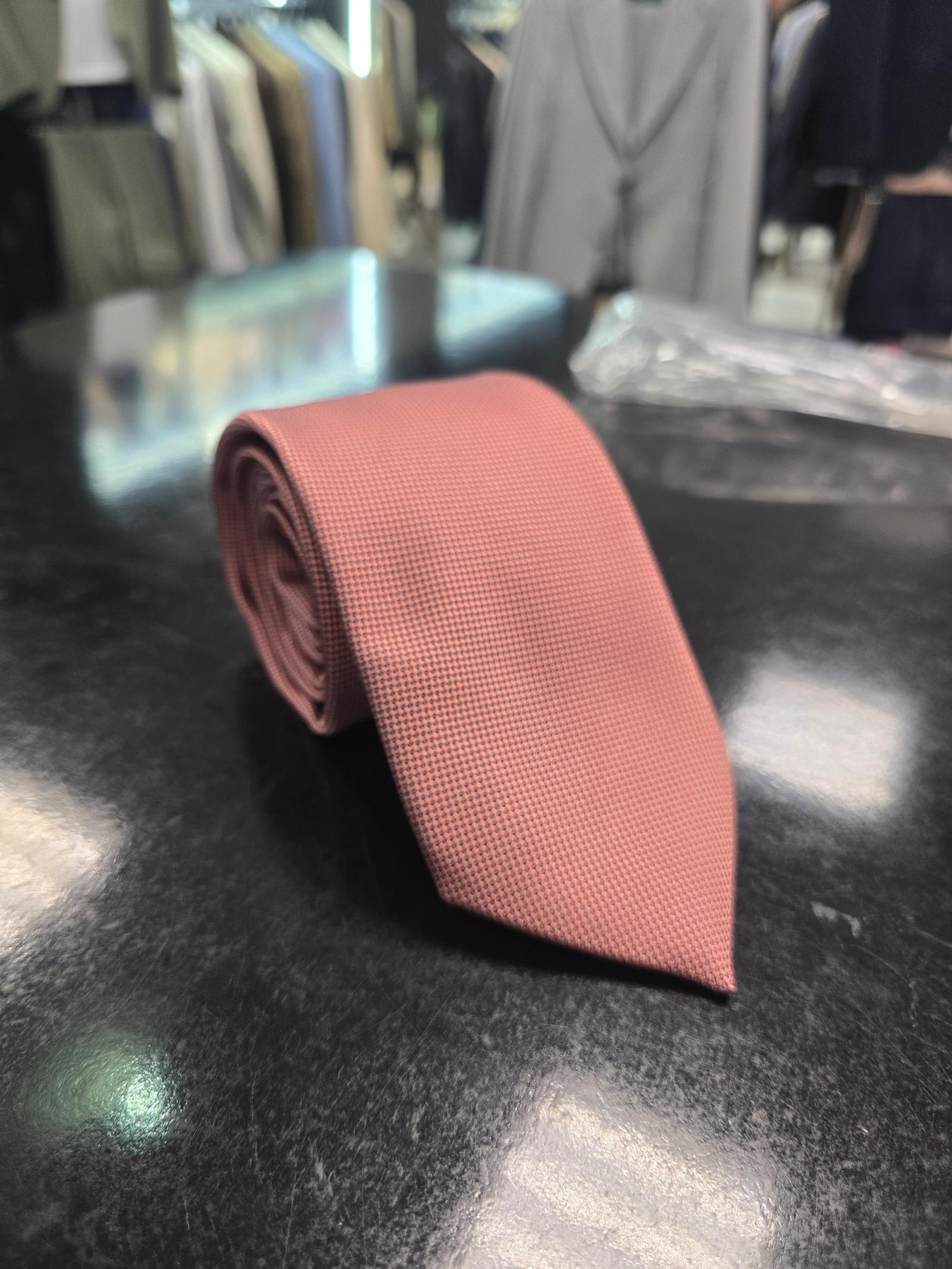 Viento powder pink textured tie, full length on dark counter
