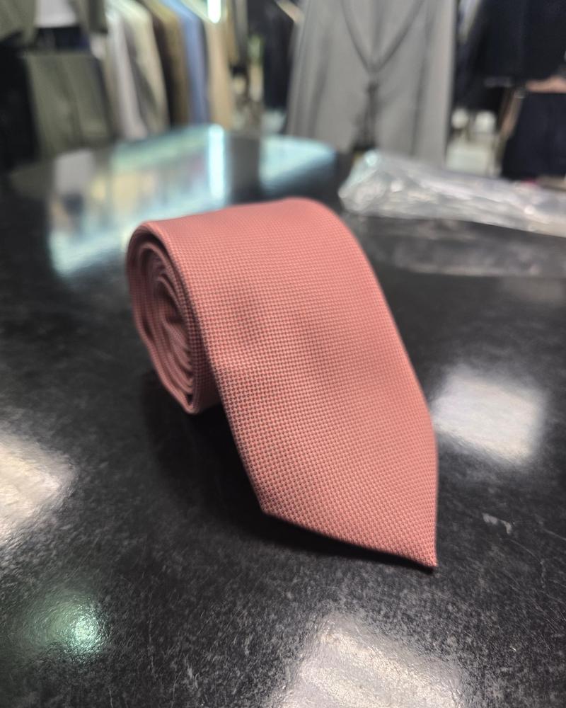 Viento powder pink textured tie, full length on dark counter