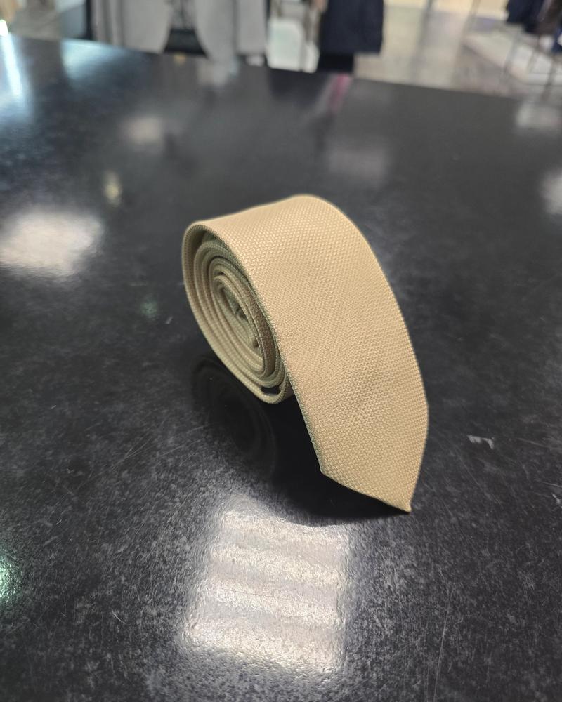 Viento beige tie, rolled view on dark counter