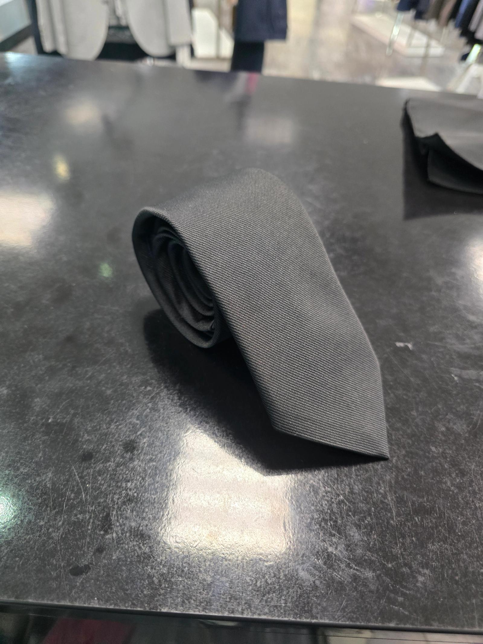 Viento black twill tie, rolled view on dark counter