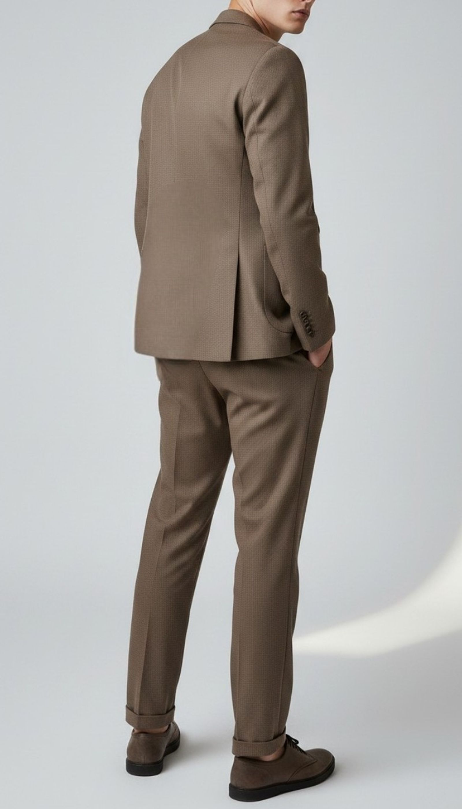 Viento brown  textured suit on a model, rear three-quarter view showing the jacket vent and tapered trousers.
