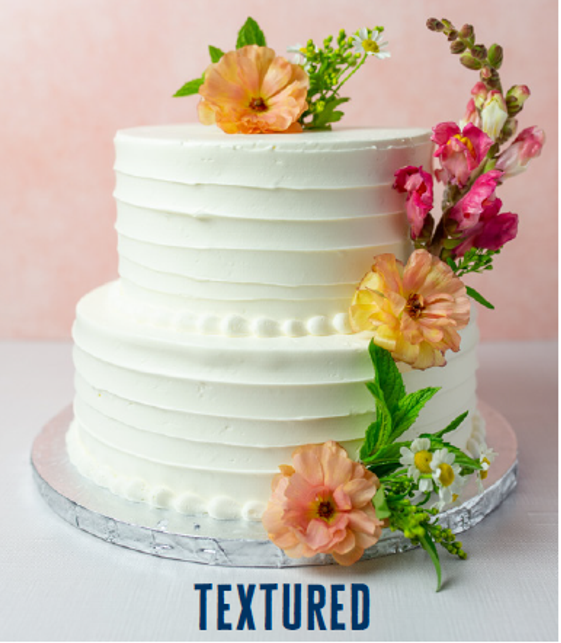 two-tiered wedding cake featuring textured buttercream and flowers