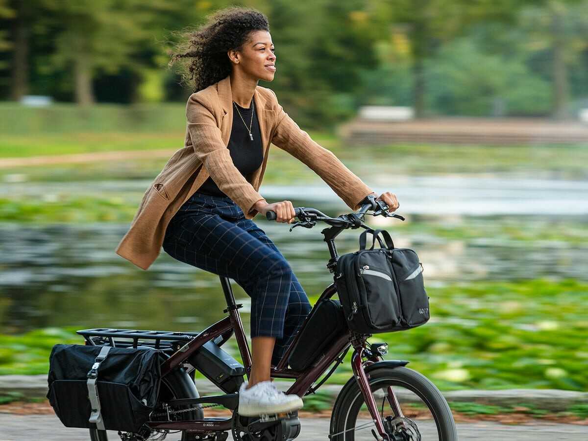 Dame i jobbtøy på Tern QuickHaul Elsykkel med vesker