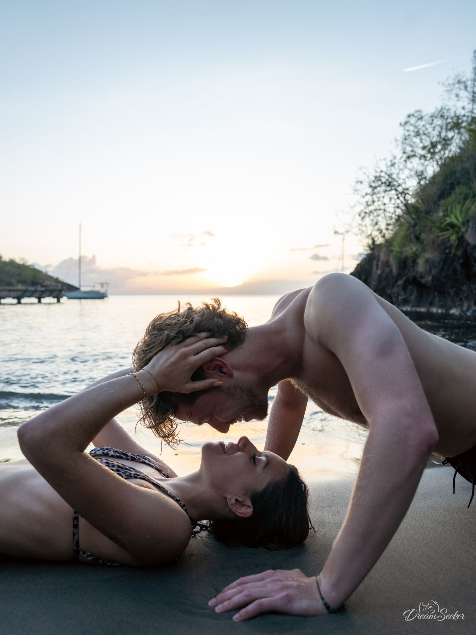 Couple allongé sur le sable, front contre front