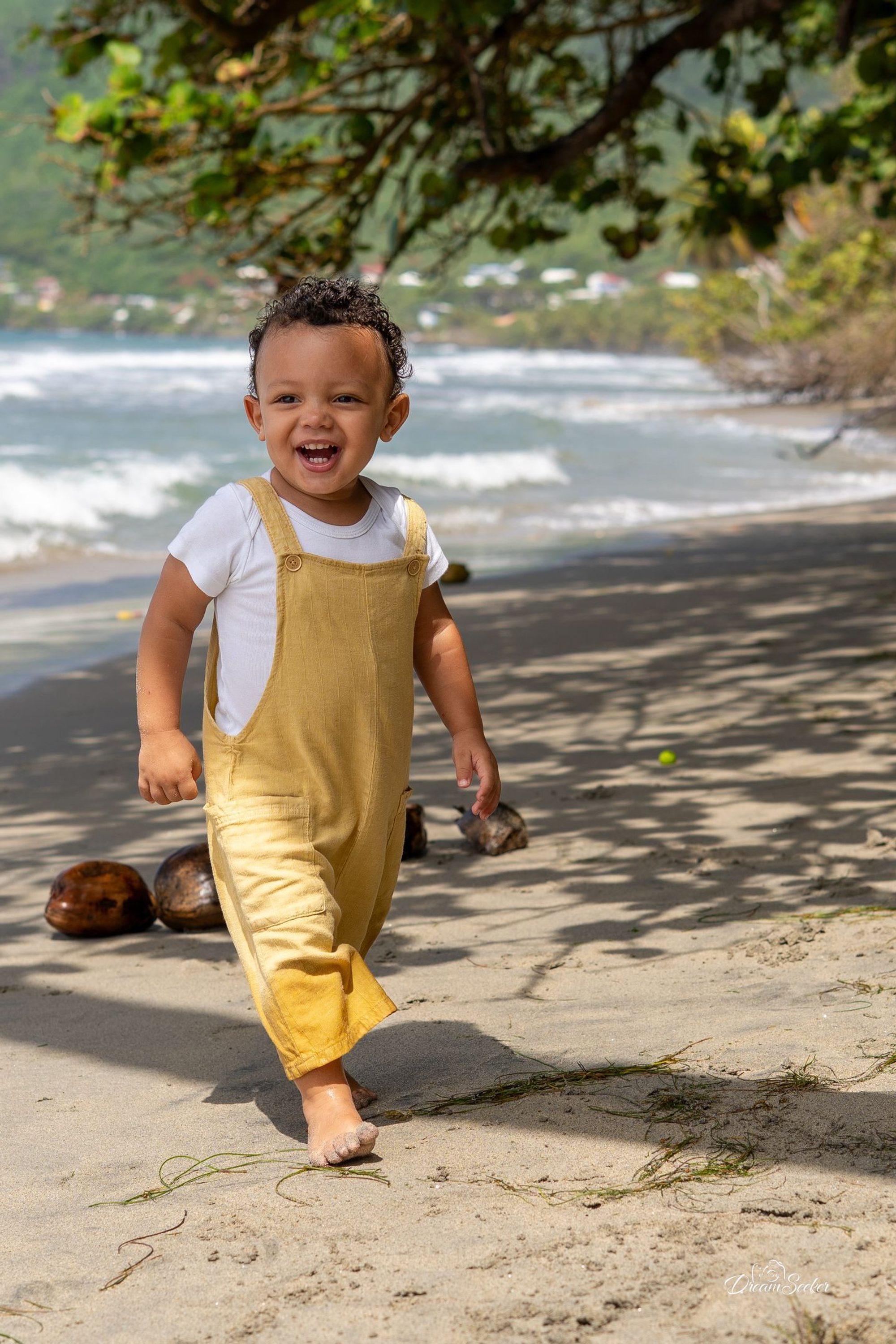 Petit garçon en salopette marchant sur la plage