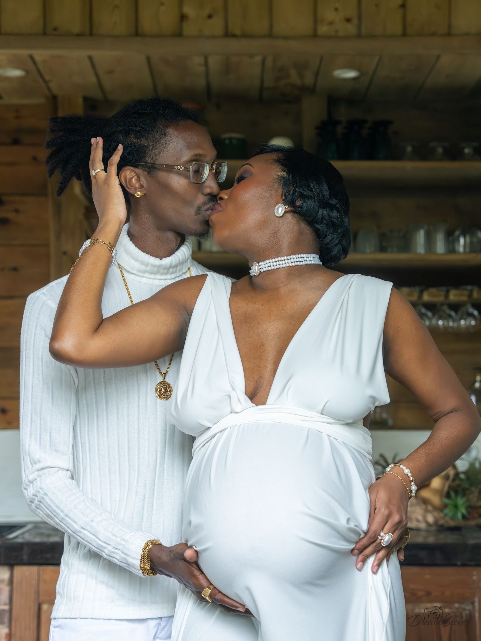 Couple en blanc s’embrassant, main sur le ventre