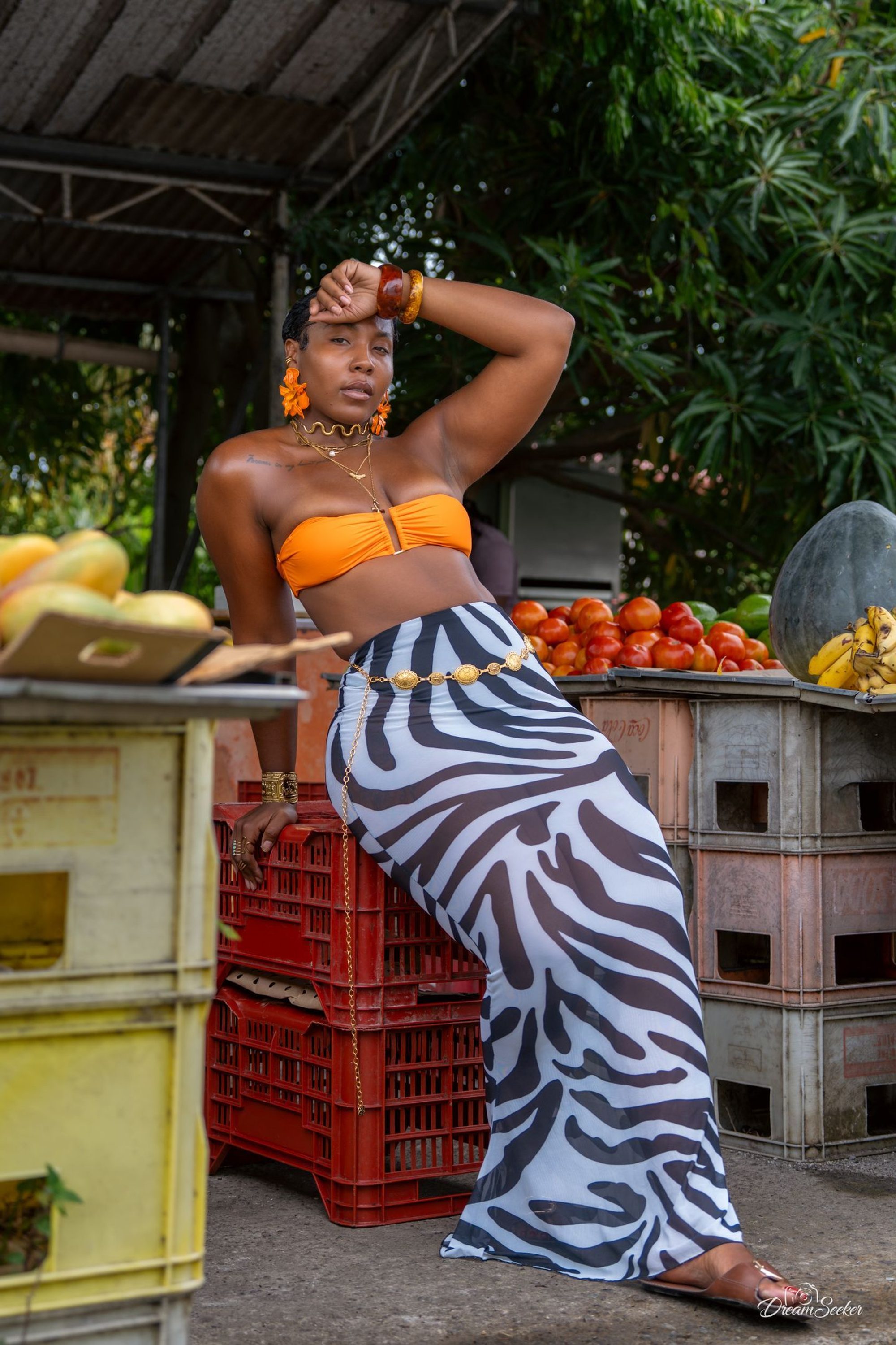 Femme posant devant un étal de fruits