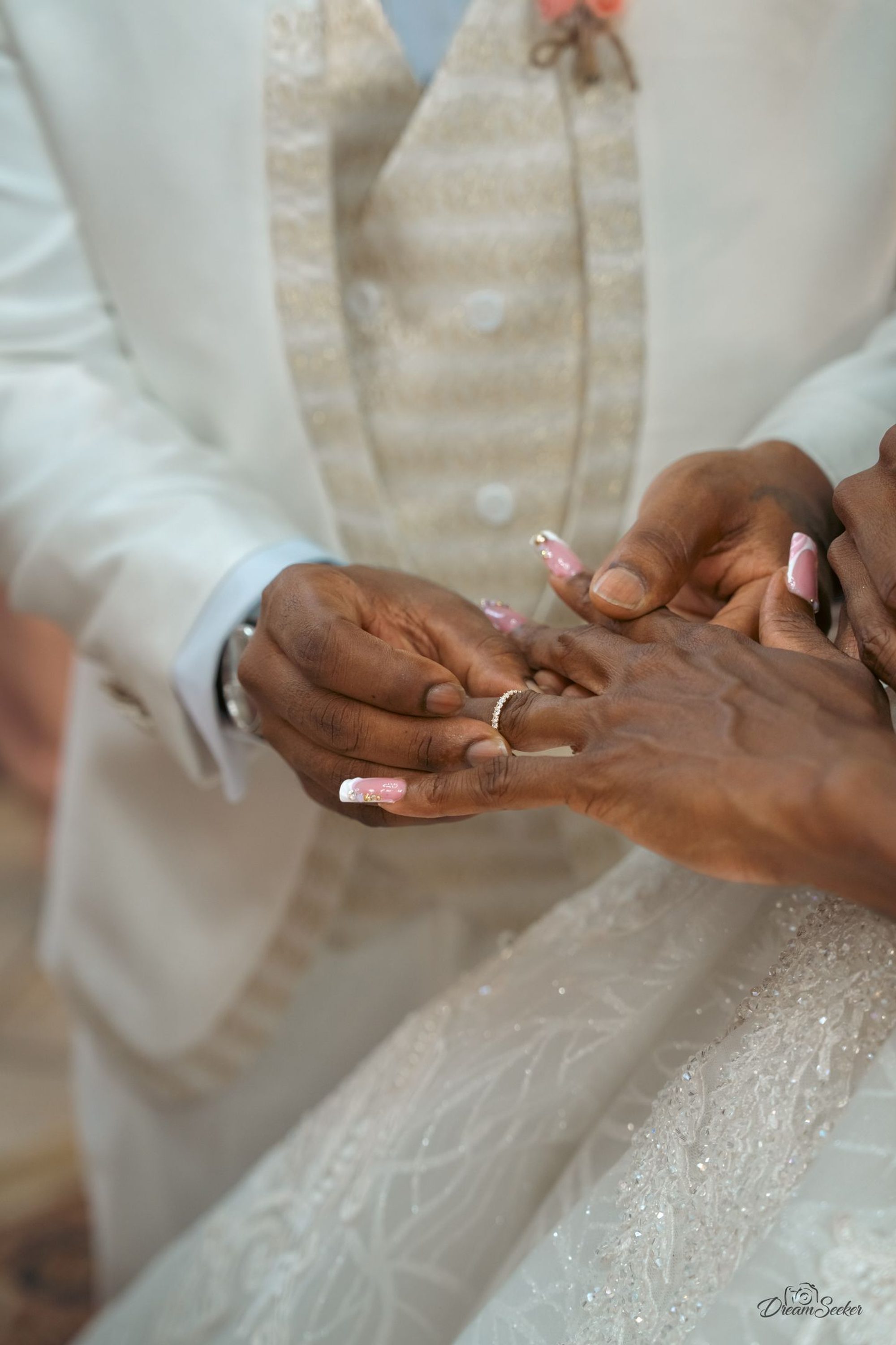 Mains de la mariée glissant l’alliance au doigt du marié