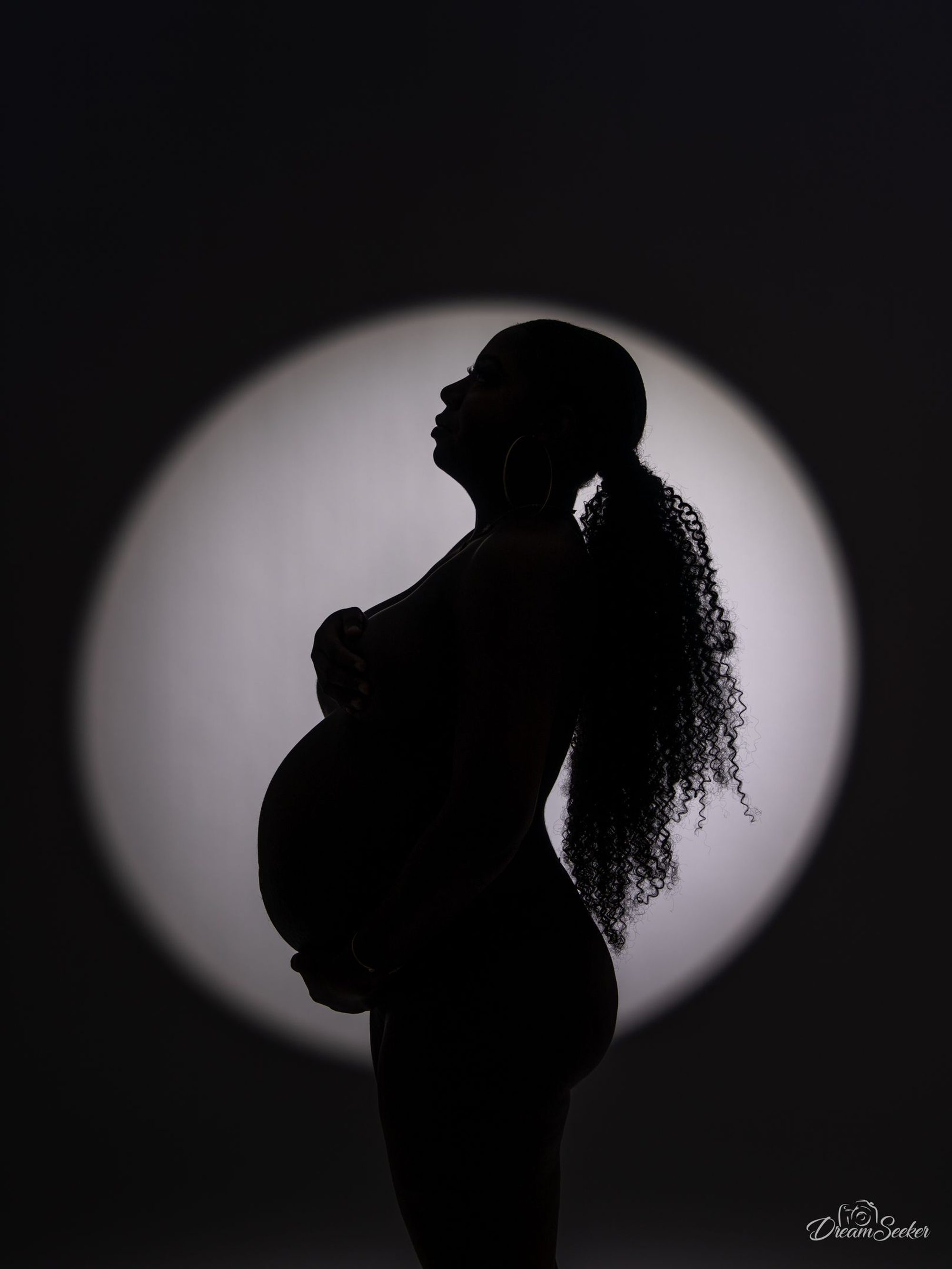 Profil d’une future mère en ombre chinoise sur un cercle de lumière