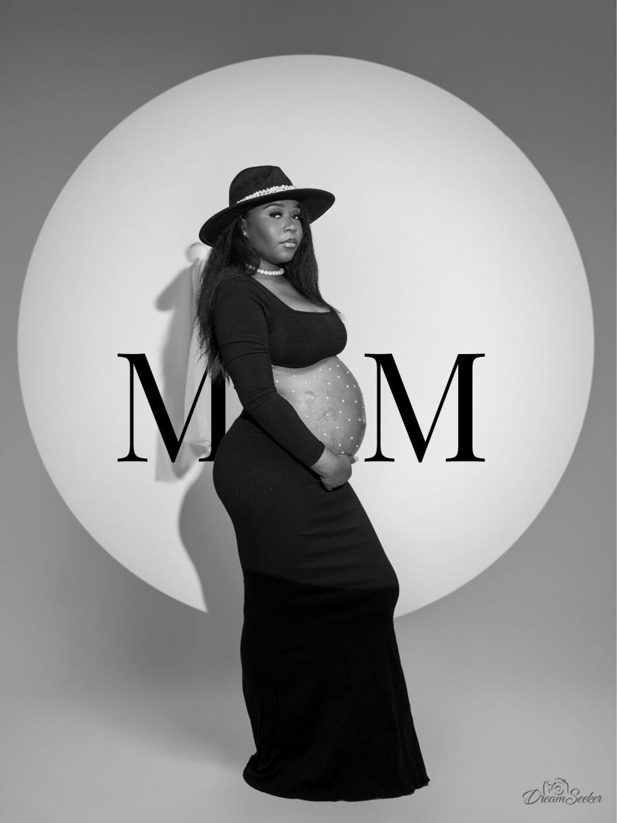 Future mère au chapeau devant un cercle portant les lettres MOM, noir et blanc