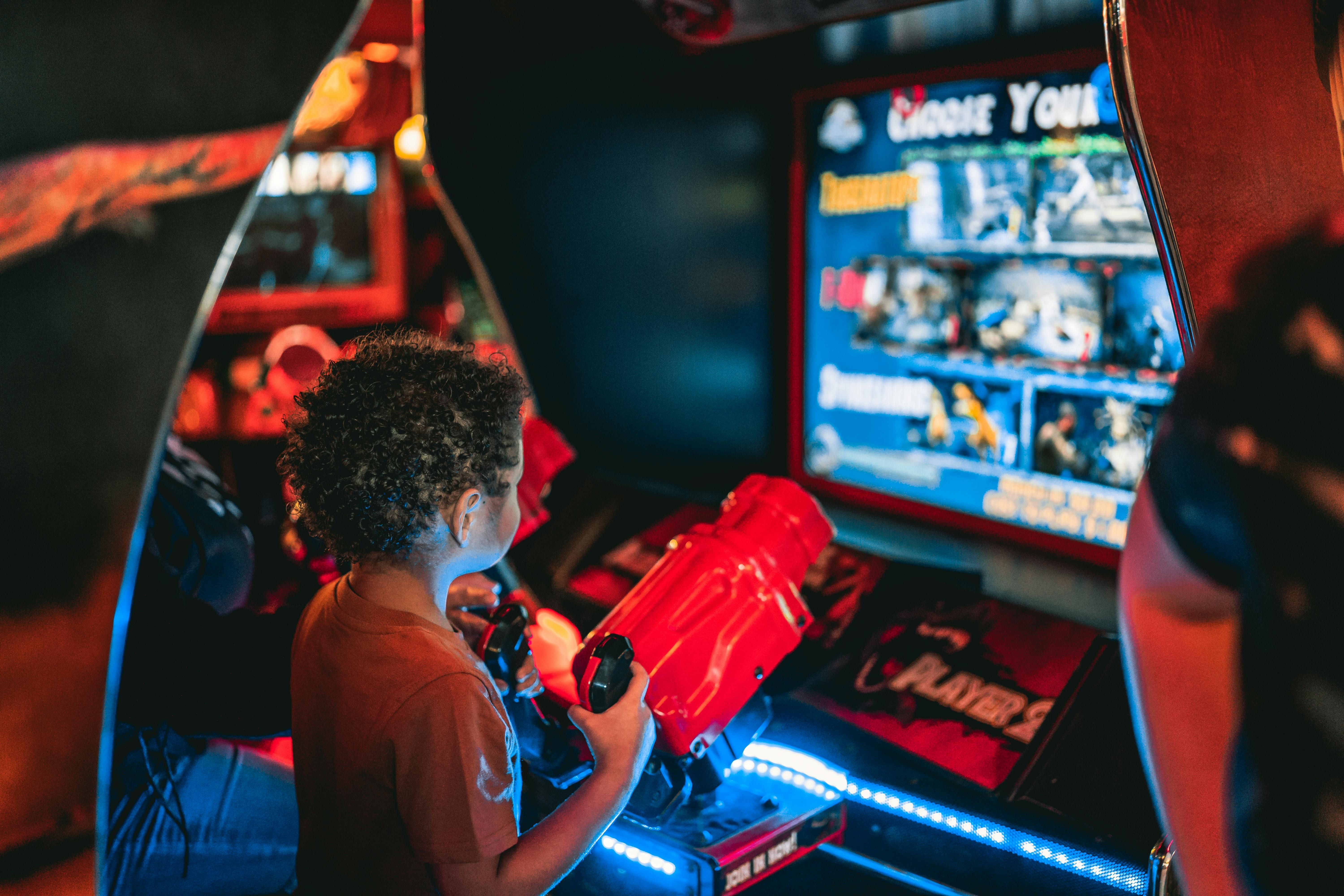 Child playing a shooting game in an arcade.