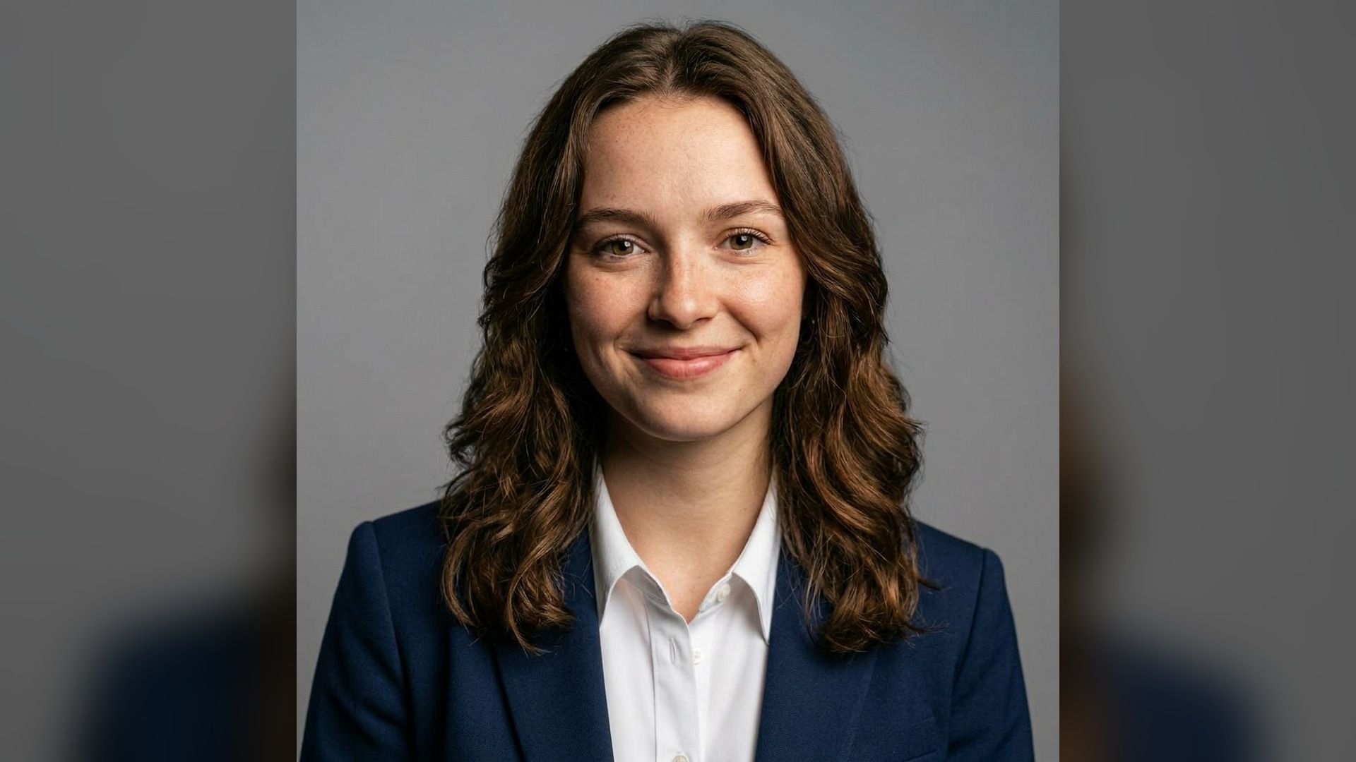 front-facing portrait with even light against a plain gray background