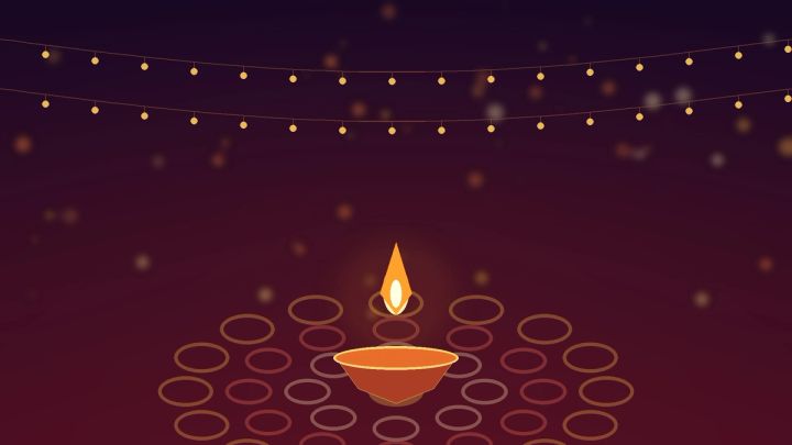 Warm Diwali photoshoot setup with a diya, rangoli pattern, and string lights