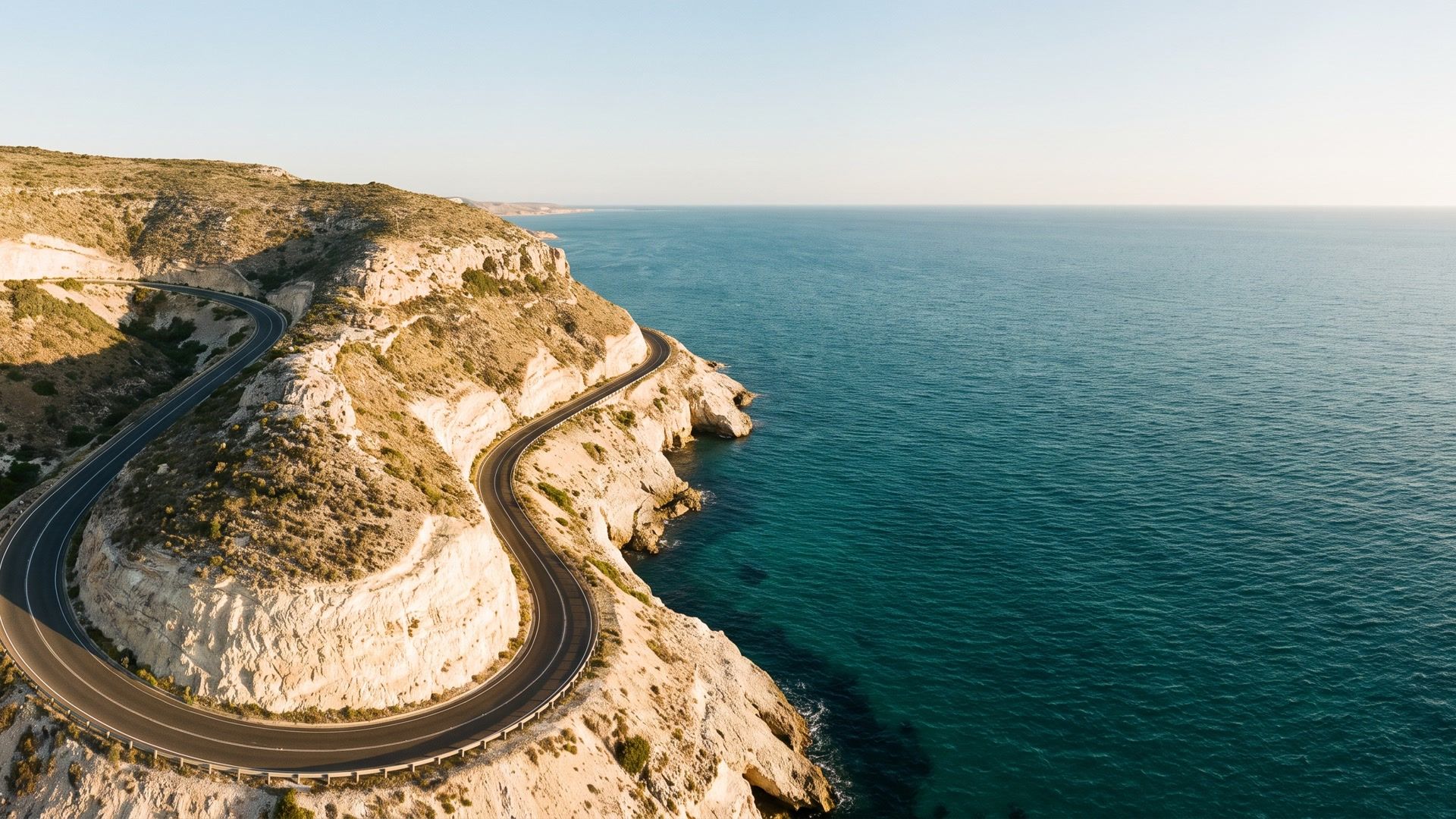 winding coastal road beside blue water in an imageat stock-image example