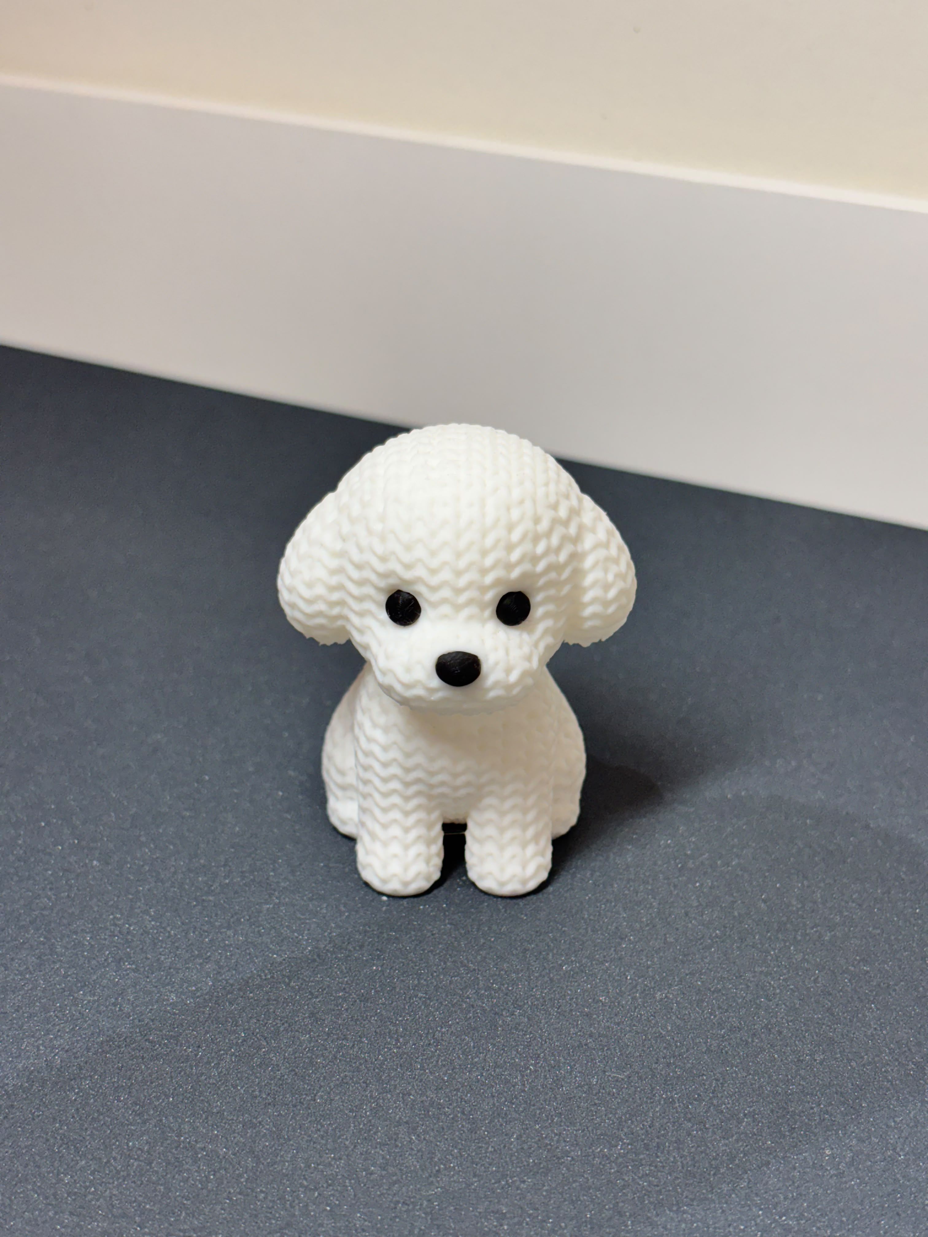 Cute 3D printed white puppy dog miniature figurine on desk