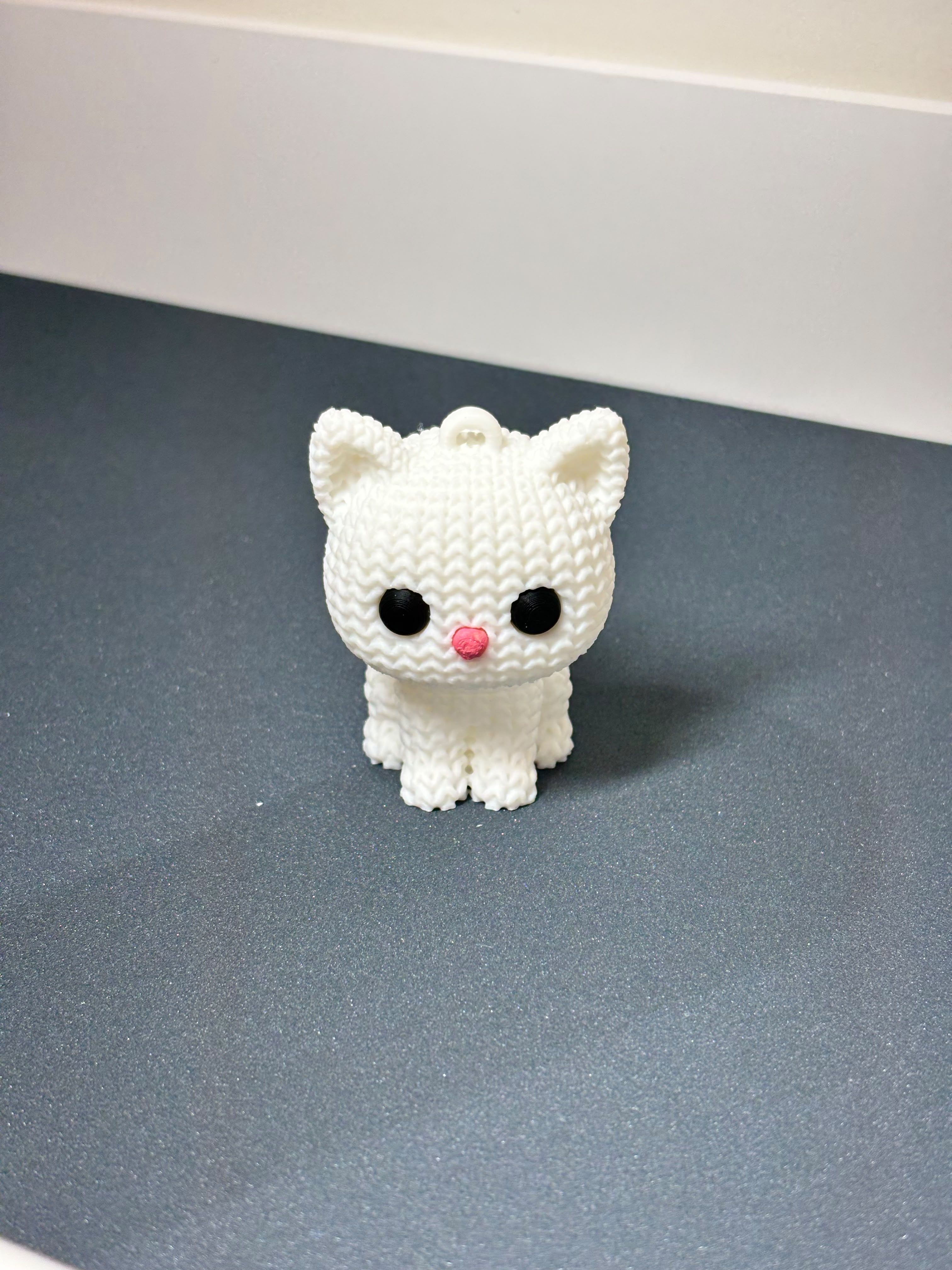 Cute 3D printed white minimalist cat figurine sitting on desk