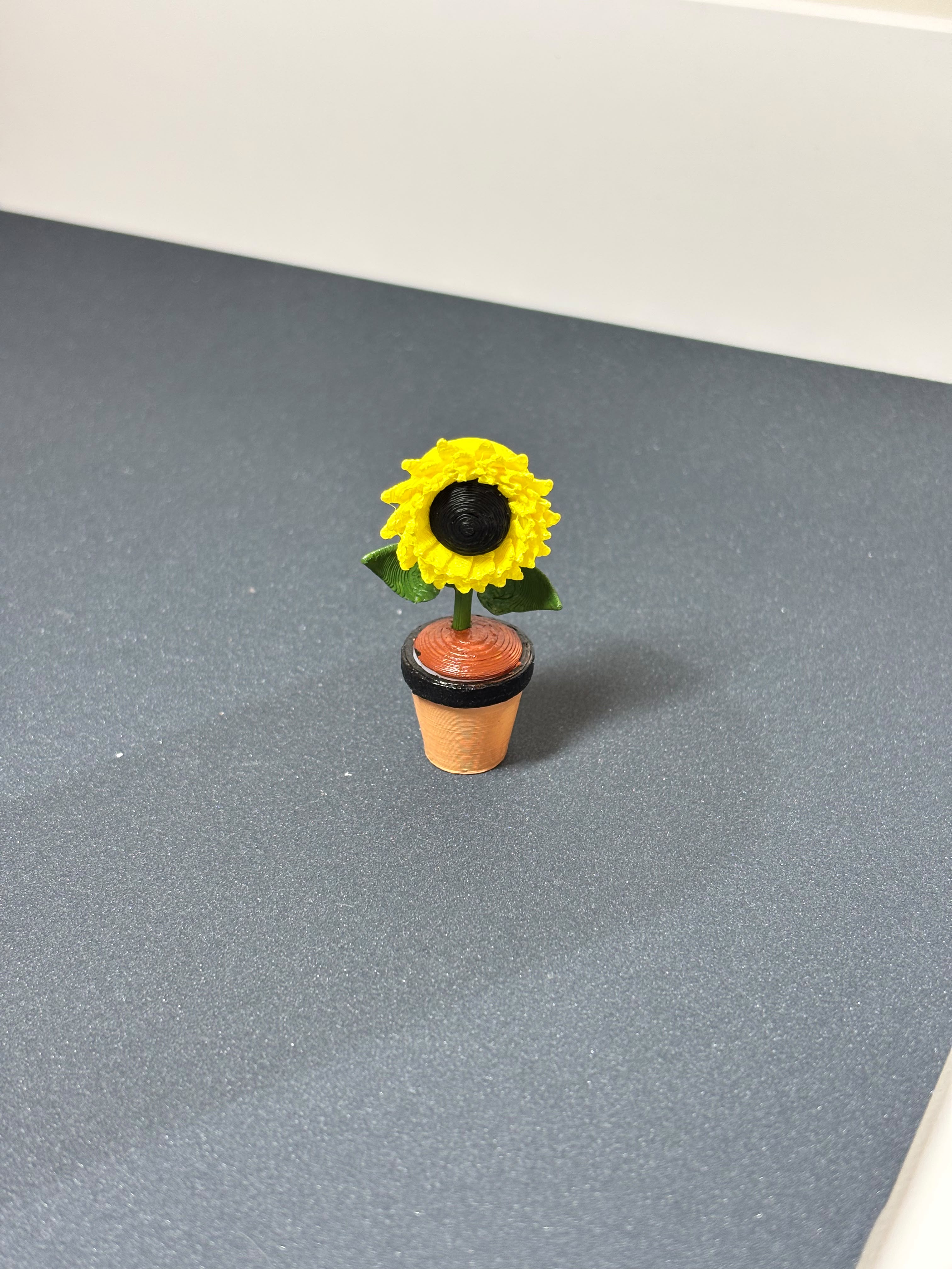 Vibrant 3D printed mini sunflower in pot on desk