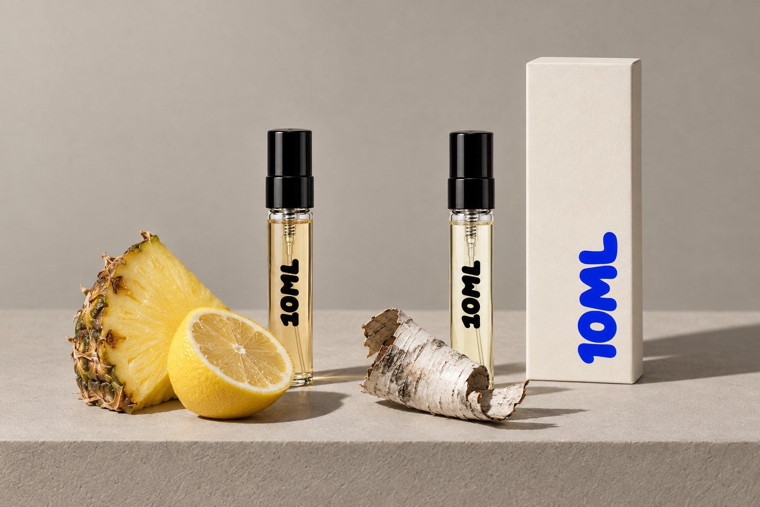 Two 10ML 3ml decants for a side-by-side test of Club de Nuit Intense Man and Aventus, beside pineapple, lemon and birch bark from their note lists