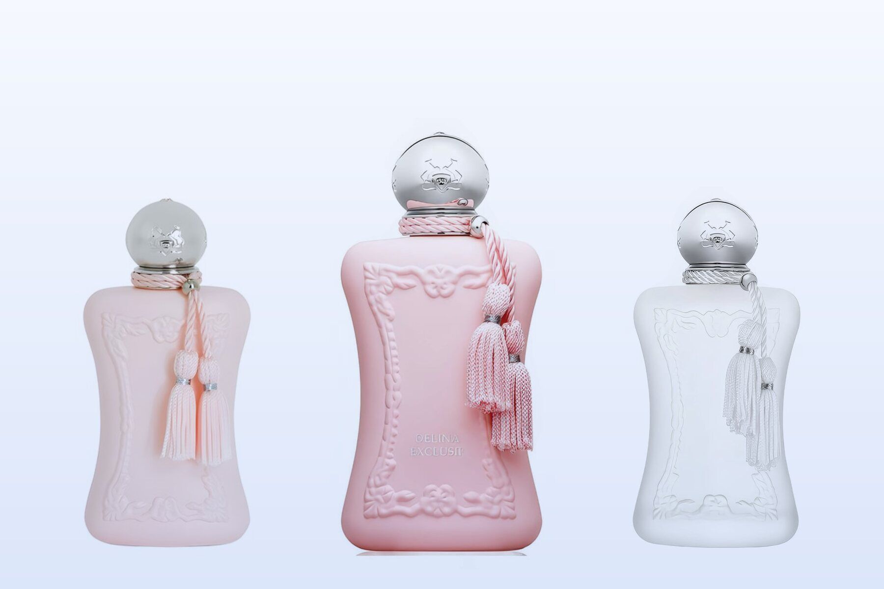 Three Parfums de Marly bottles, Delina, Delina Exclusif and Valaya, on a pale blue background