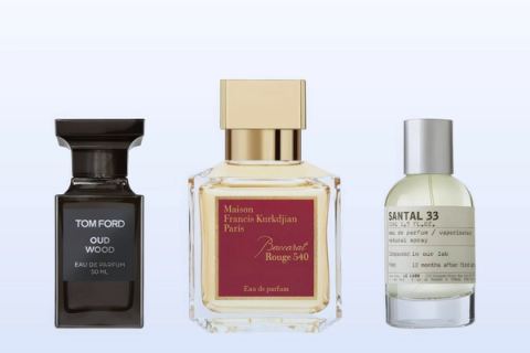 Three fragrance bottles, Oud Wood, Baccarat Rouge 540 and Santal 33, on a pale blue background