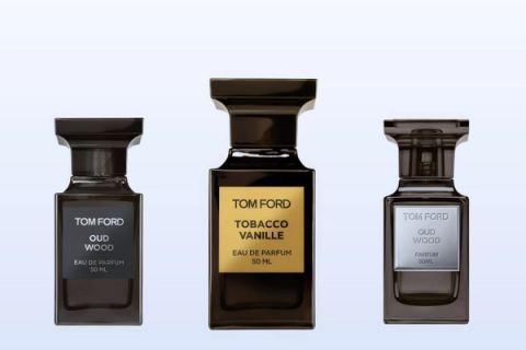Három Tom Ford üveg, az Oud Wood, a Tobacco Vanille és az Oud Wood Parfum, halványkék háttér előtt