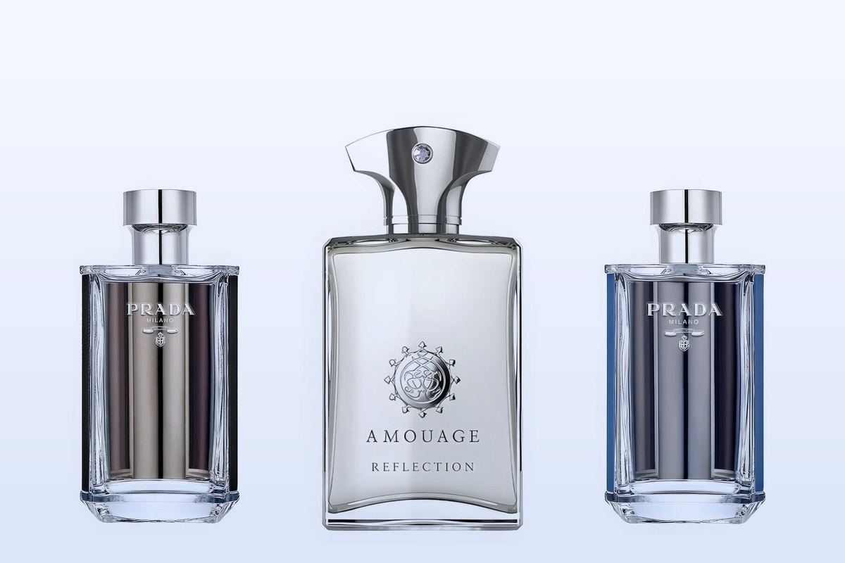 Tre flaconi su uno sfondo azzurro pallido: Prada L'Homme, Reflection Man di Amouage e Prada L'Homme L'Eau