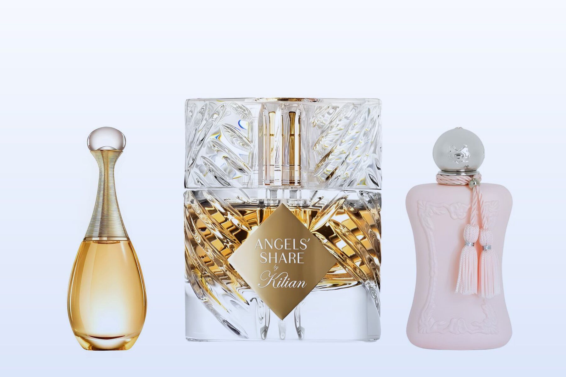 Three fragrance bottles, J'adore, Angels' Share and Delina, on a pale blue background