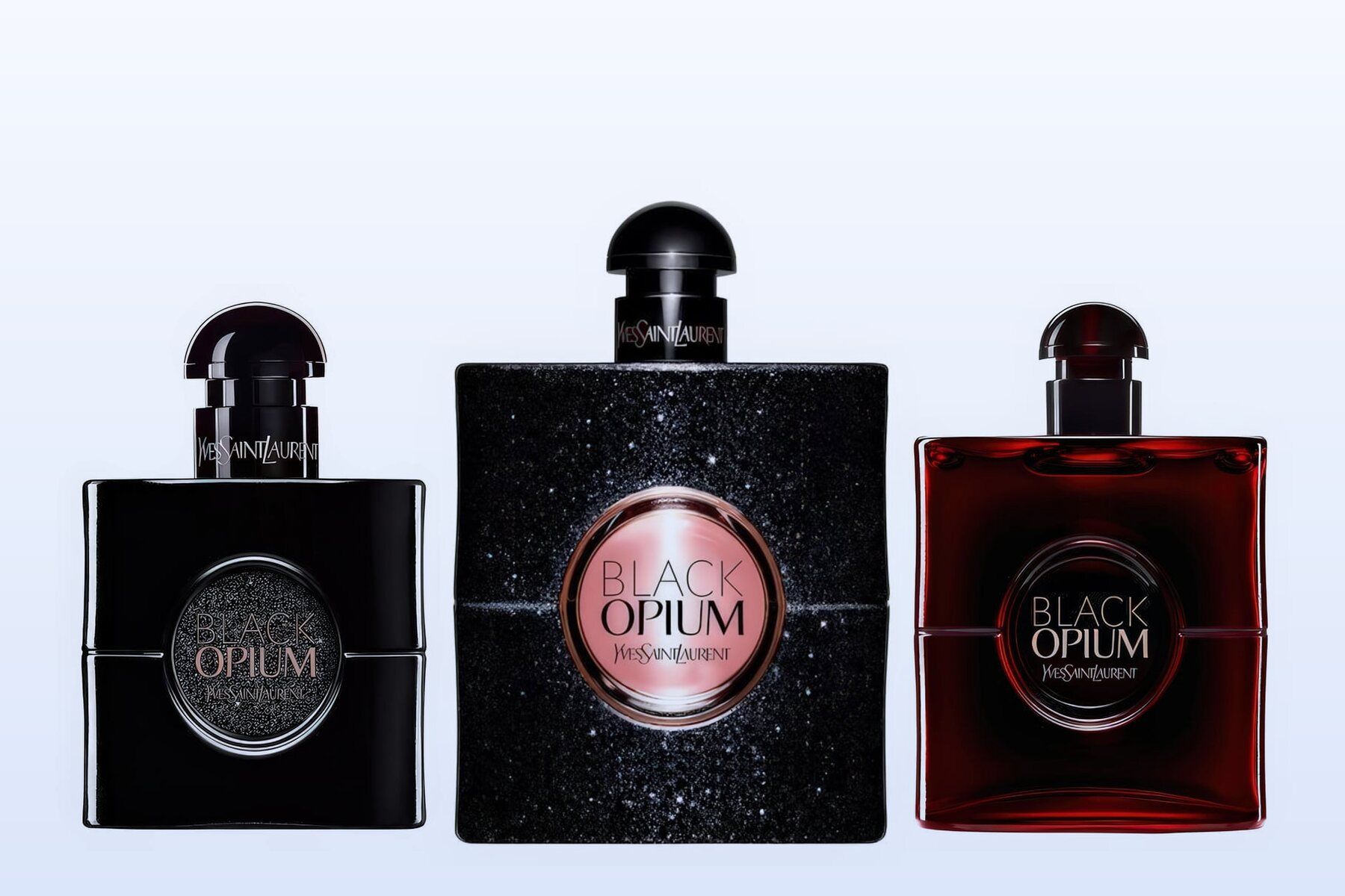 Three fragrance bottles, Black Opium Le Parfum, Black Opium and Black Opium Over Red, on a pale blue background