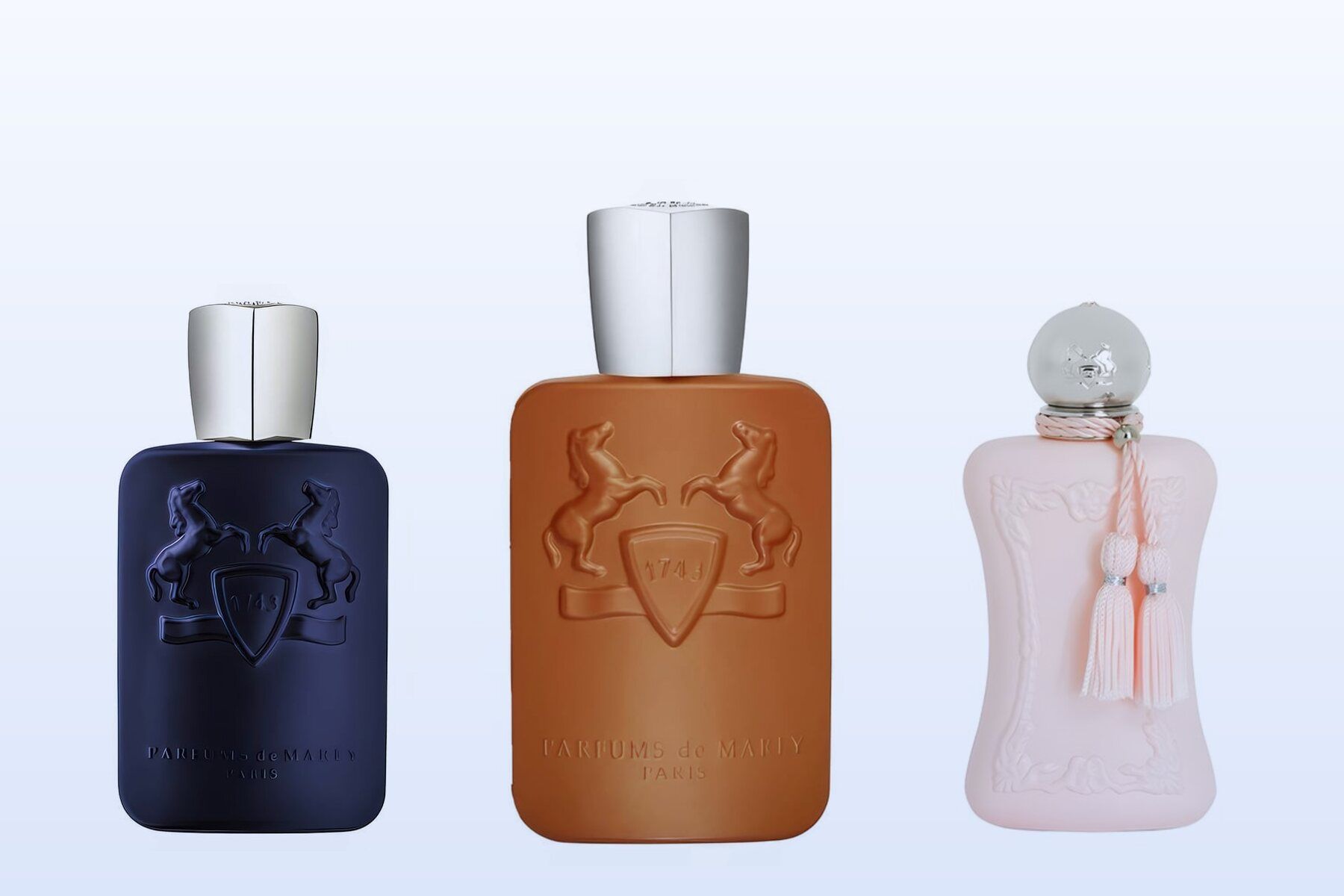 Three bottles on a pale blue background, Layton, Althaïr and Delina by Parfums de Marly