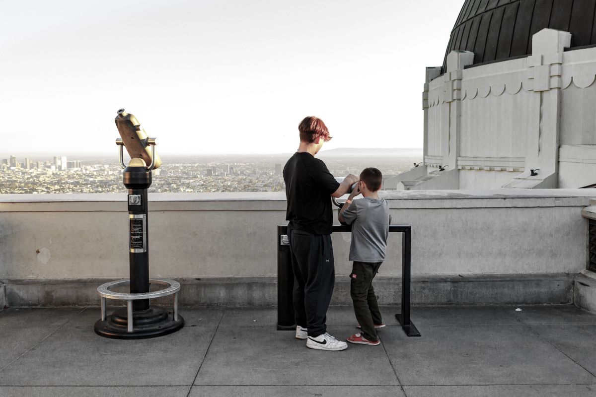 Two kids stand on the balcony of the Observatory looking out over the city