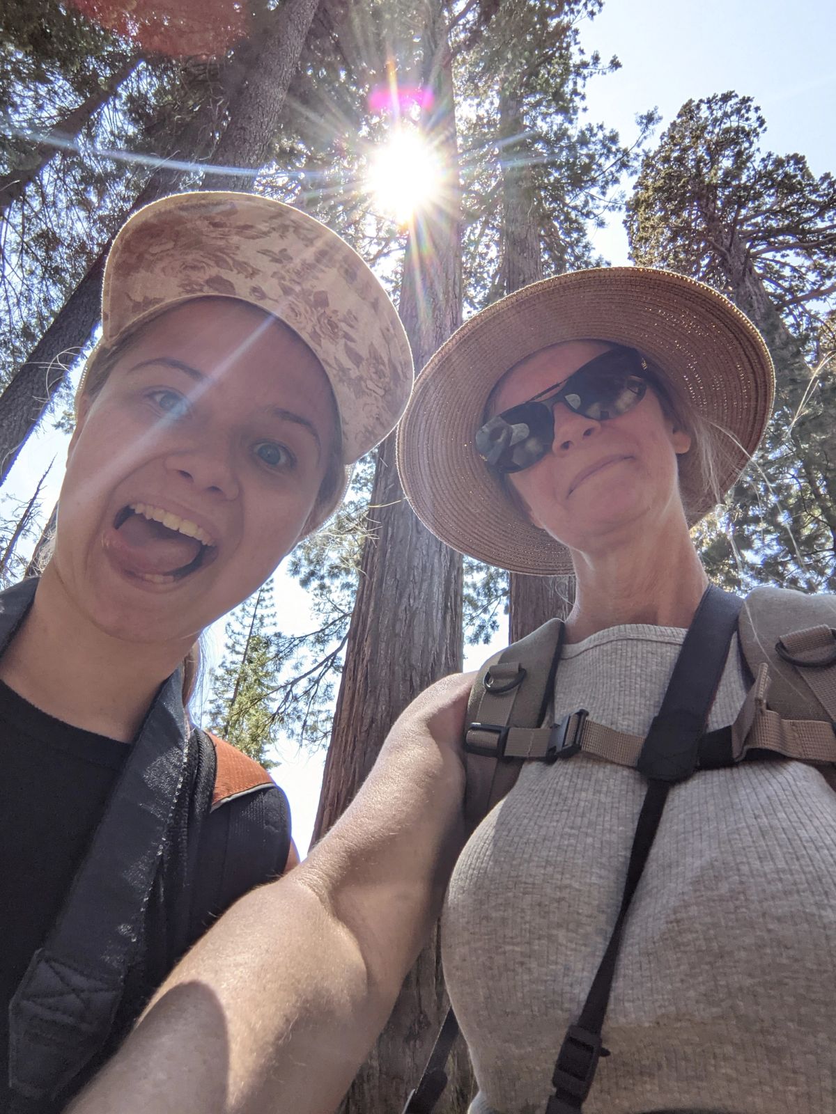 Mother and daughter taking a silly selfie with trees in the background