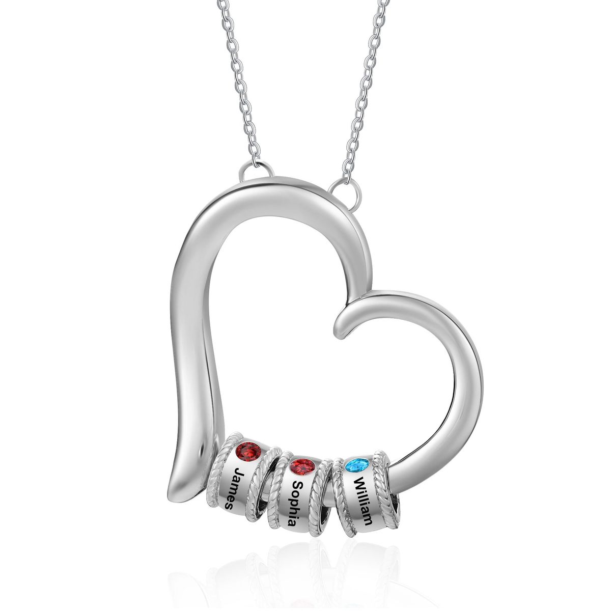 Gold personalized heart necklace engraved with names and set with colored family birthstones, resting on cream fabric