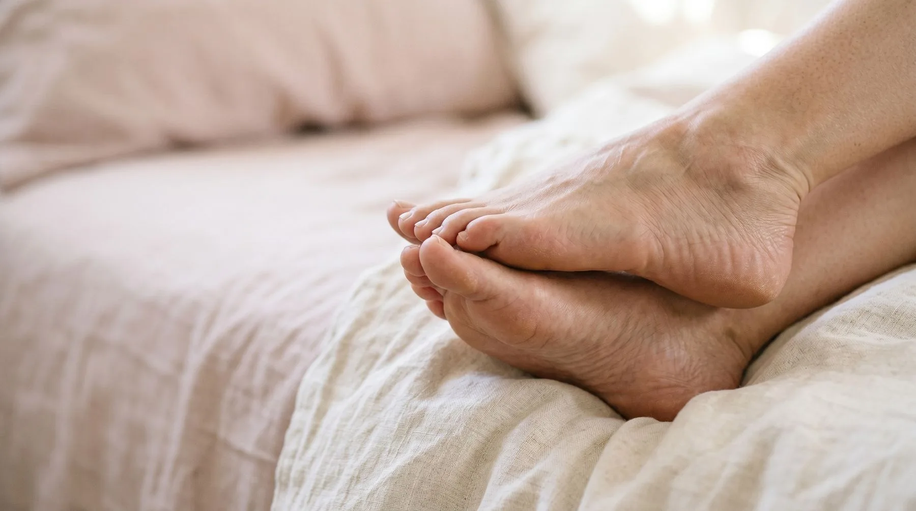 Dry skin on feet — bare feet on cream linen