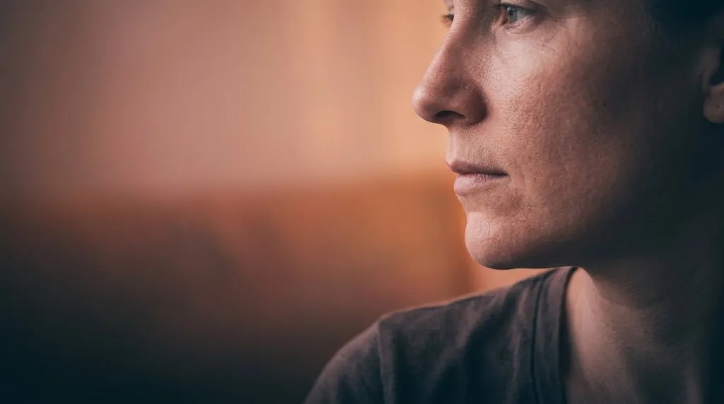 A figure in a quiet interior, observed in window light