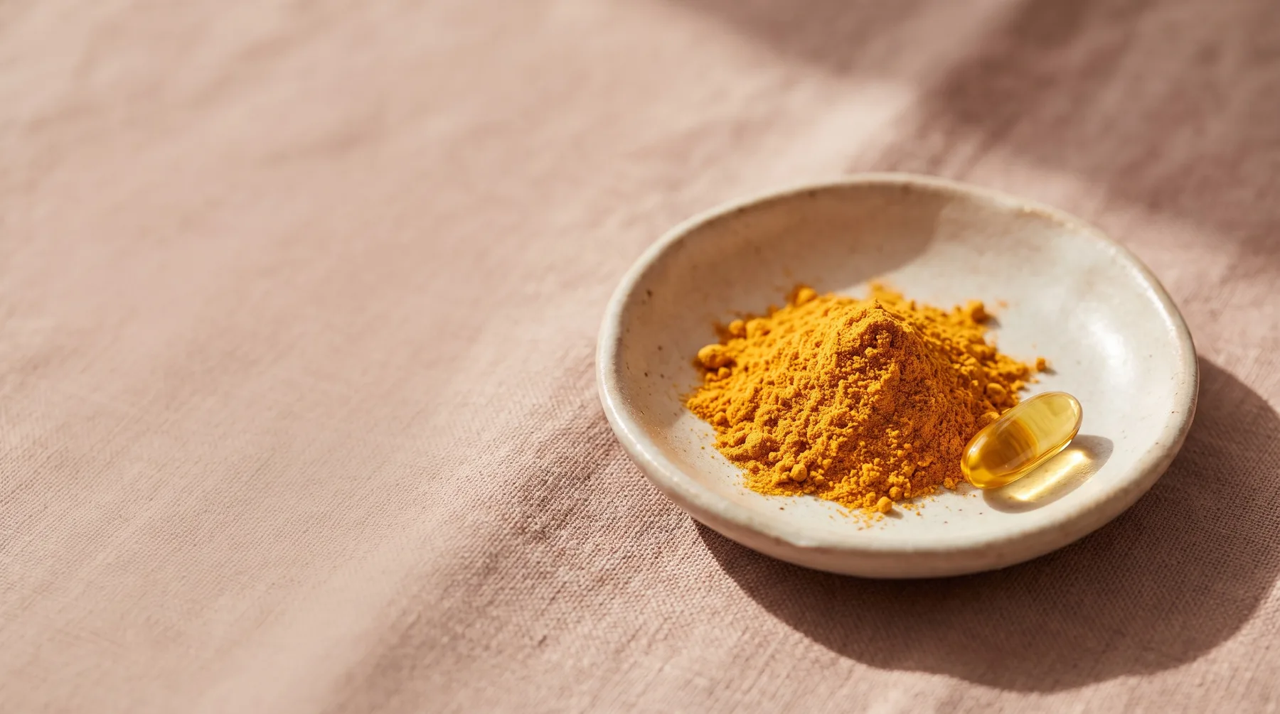 Ubiquinone (CoQ10) — a dish of golden CoQ10 powder beside a golden softgel on warm linen