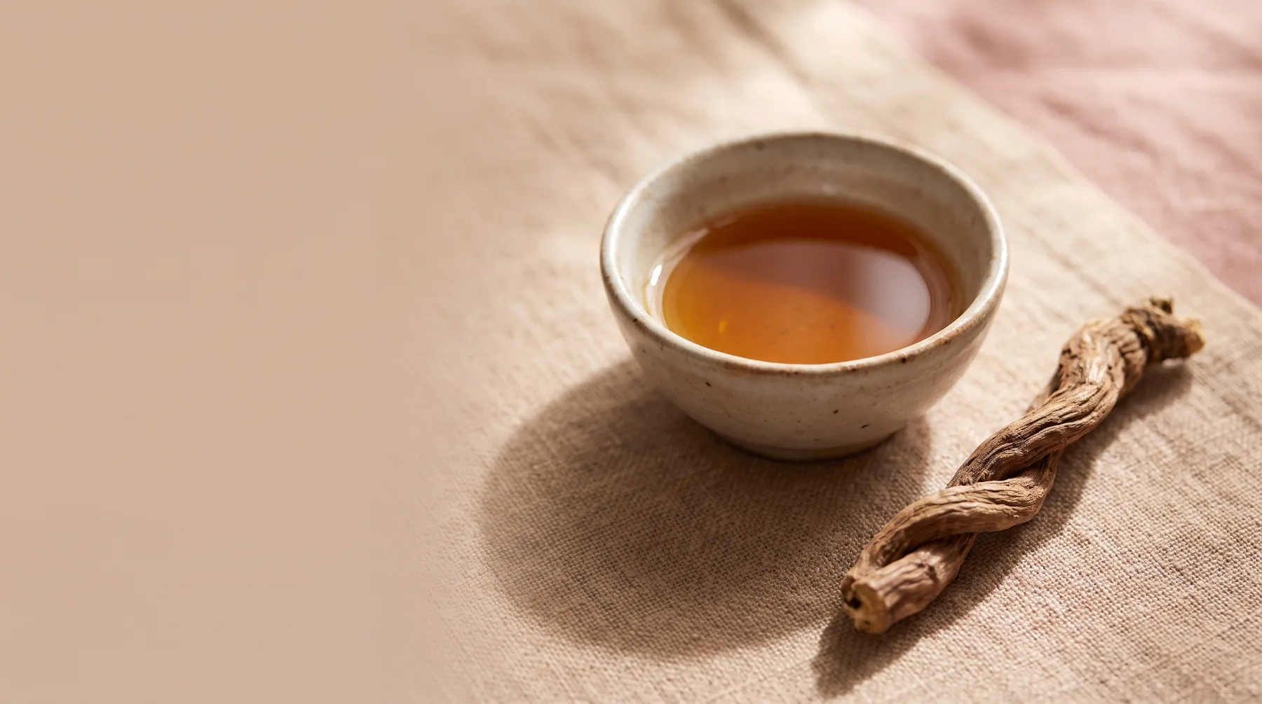 Spikenard oil — a vessel of amber spikenard oil beside dried spikenard root on warm linen