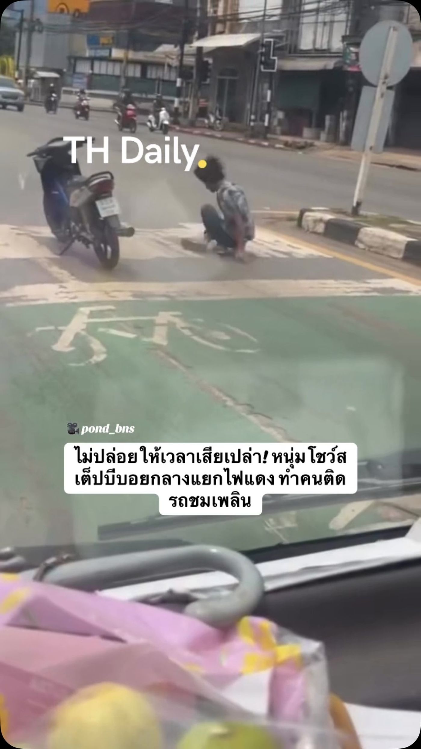 Motorcyclist performs a b-boy routine at a red light