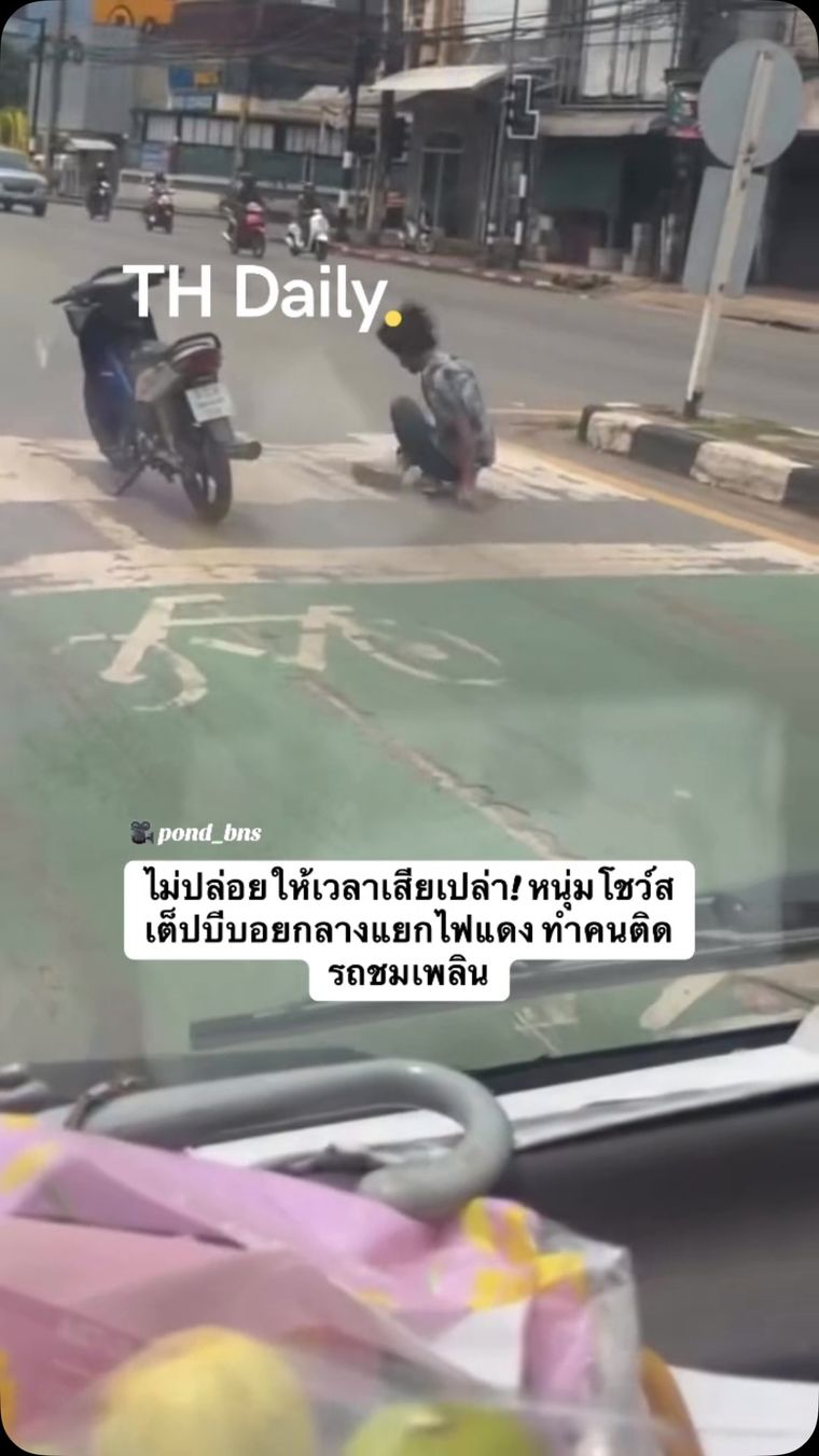 Motorcyclist performs a b-boy routine at a red light