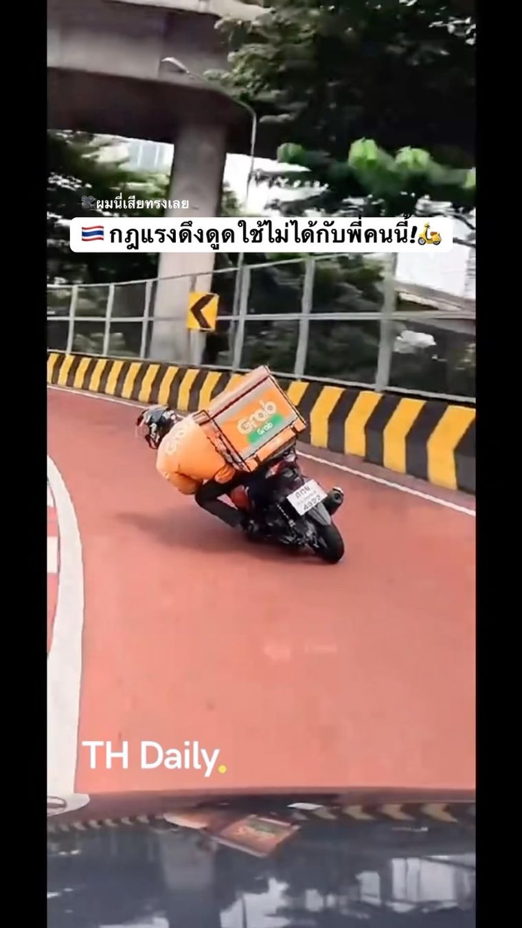 Delivery rider leans low through a road bend
