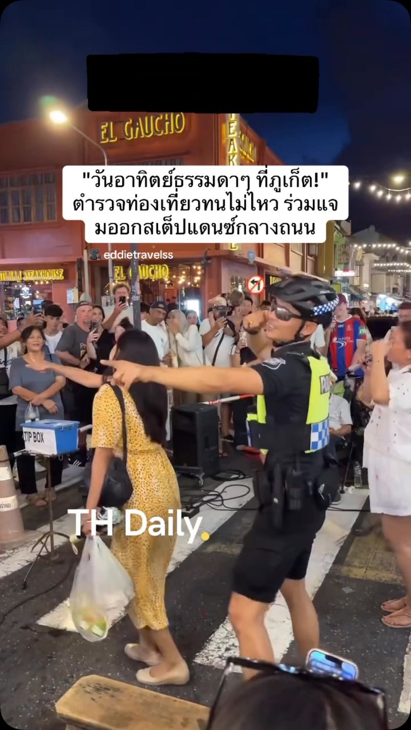 Tourist police officer joins dancers at Phuket Old Town walking street