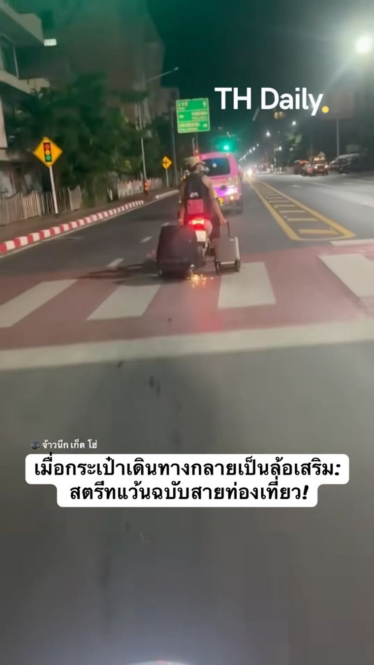 Motorcyclist drags a suitcase along the road