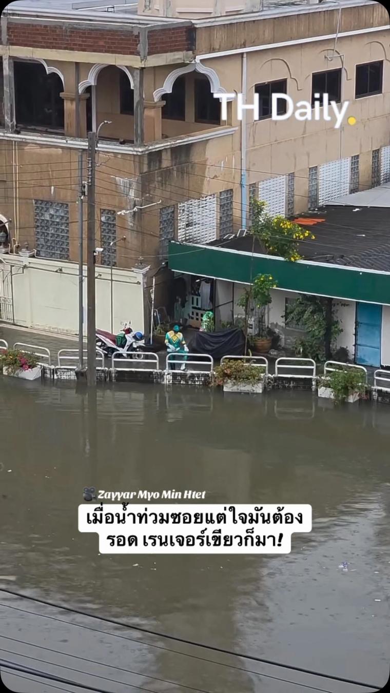 Person in Green Ranger costume walks beside flooded street