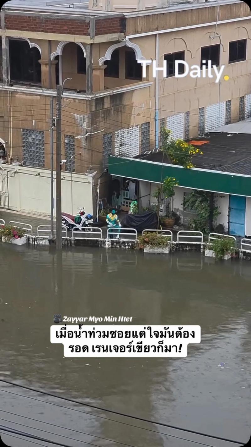 Person in Green Ranger costume walks beside flooded street
